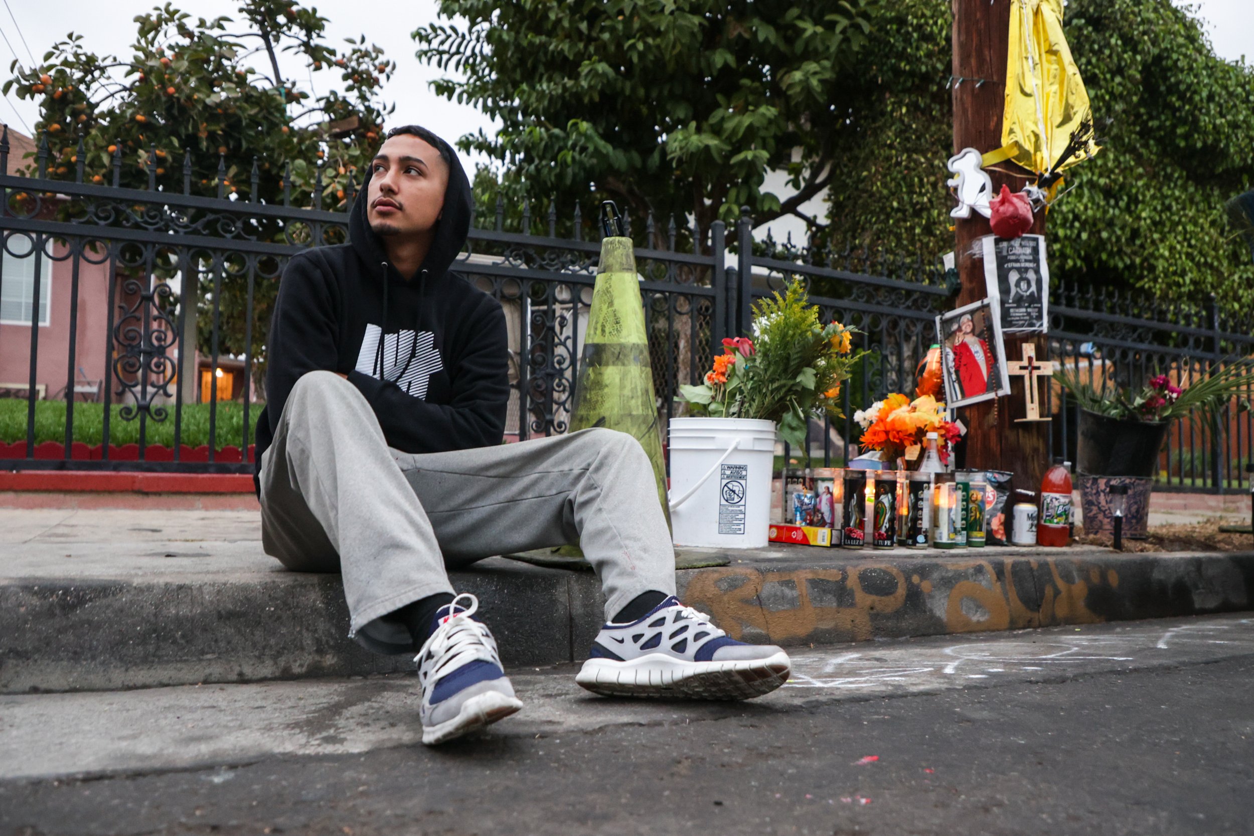  Fernando Aguilera poses for a portrait on October 14, 2022, sitting on the curb where his best friend died. Aguilera was in the car when his best friend Efrain Moreno Jr. was fatally shot and killed. Aguilera, on the one-month anniversary of Moreno'
