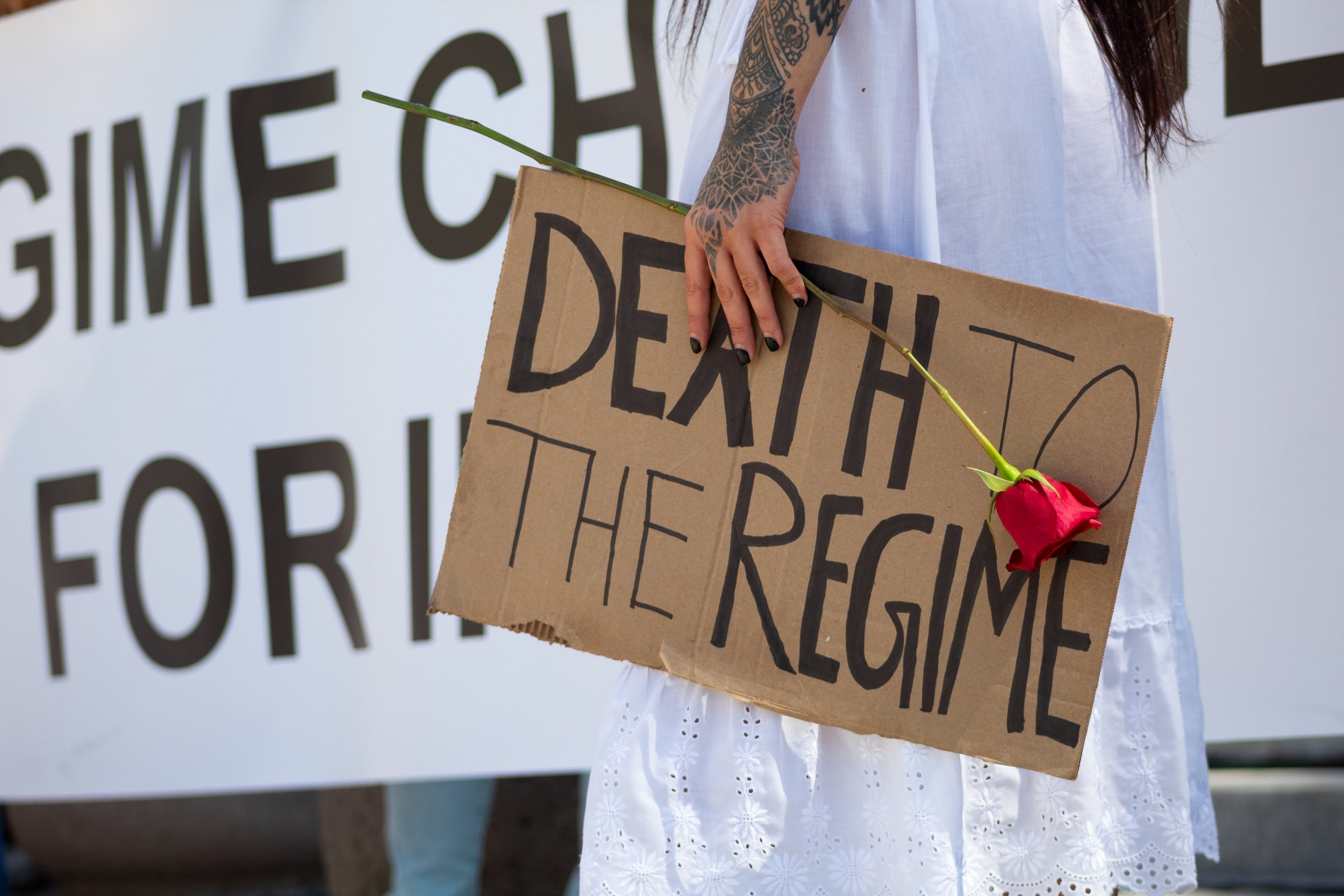  Leila [lastname withheld] holding a rose and sign that reads "death to the regime" at the Freedom For Iran rally on the steps of Los Angeles City Hall. The rally marched from Pershing Square with at least a thousand people in attendance as well as b
