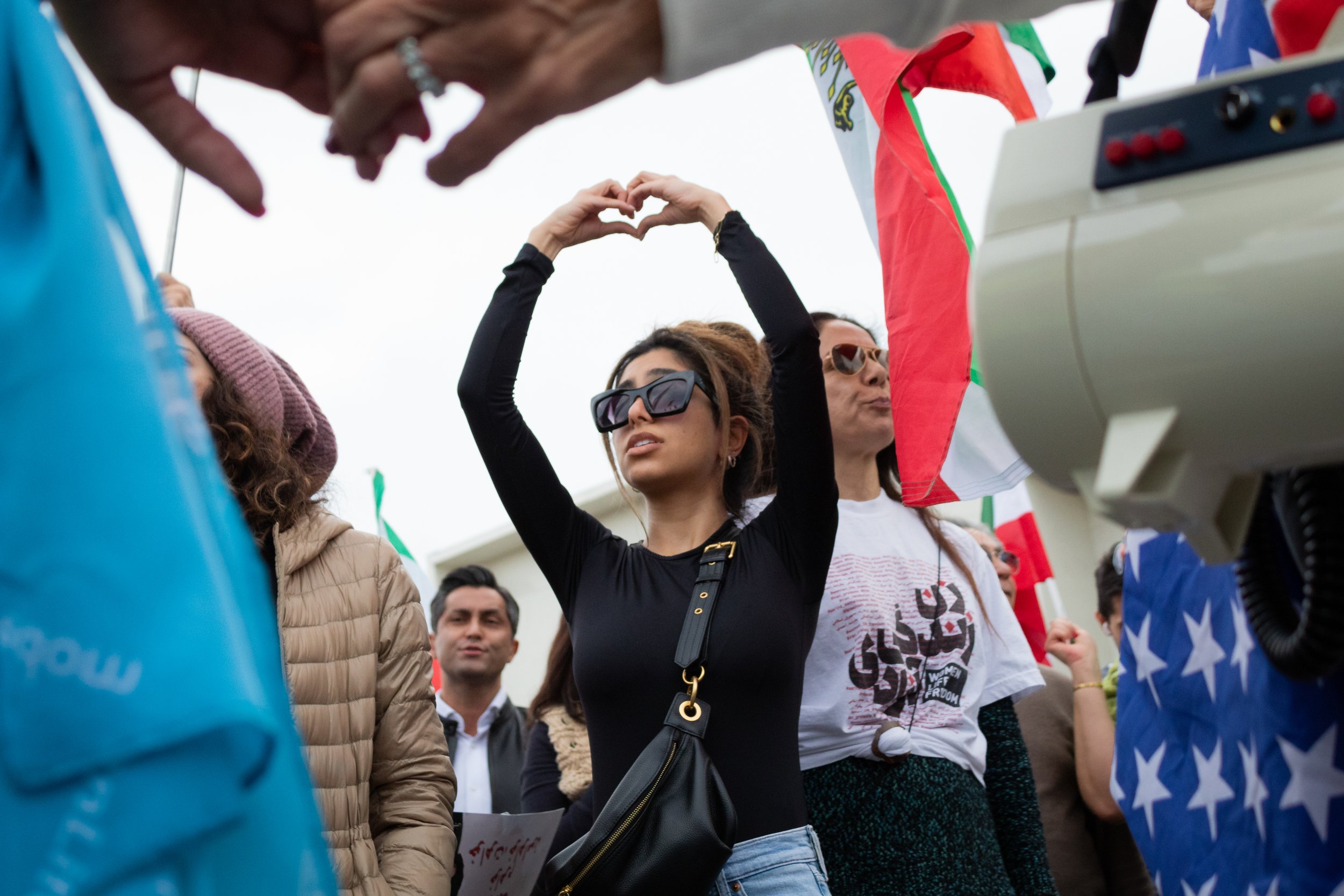  A demonstrator holding her hands in the shape of a heart while the Iranian national athem from before the revolution is playing during the Freedom for Iran rally in Los Angeles, Calif. on Saturday, Dec. 17, 2022. 