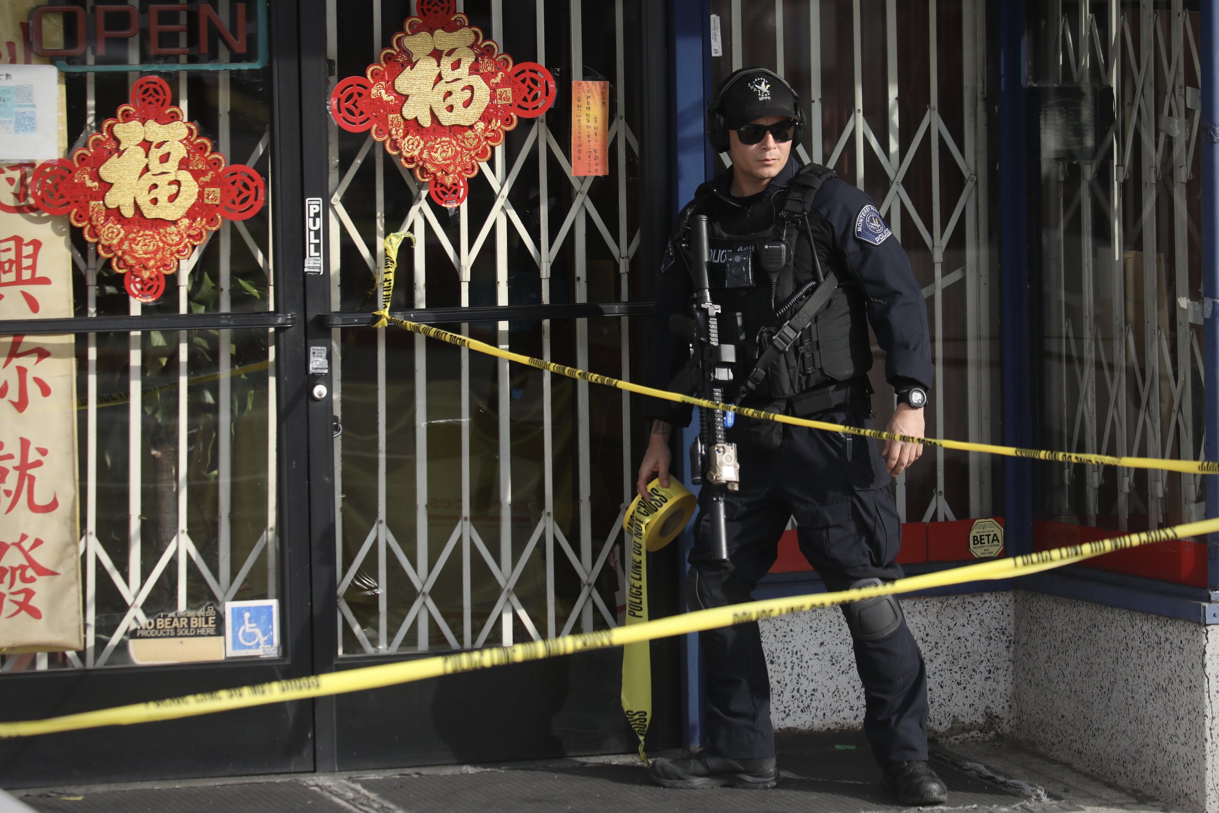  A heavily armed policeman blocks off a sidewalk near the Star Ballroom after a mass shooting during Chinese Lunar New Year celebrations in Monterey Park, California, U.S.  