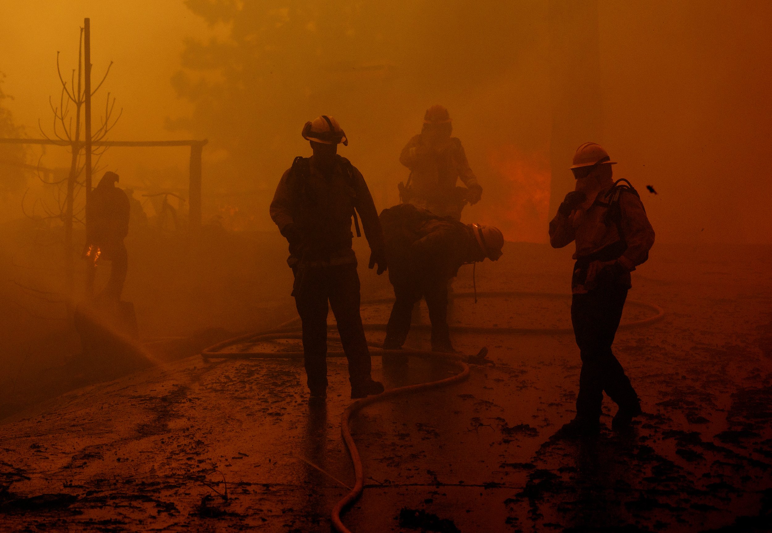  RUNNING SPRINGS, CA - The air is smoky and dense as firefighters are overcome with smoke while battling a house fire as the Line fire burns on September 10,  2024 in Running Springs, California. This is one of three major wildfires burning in the sa