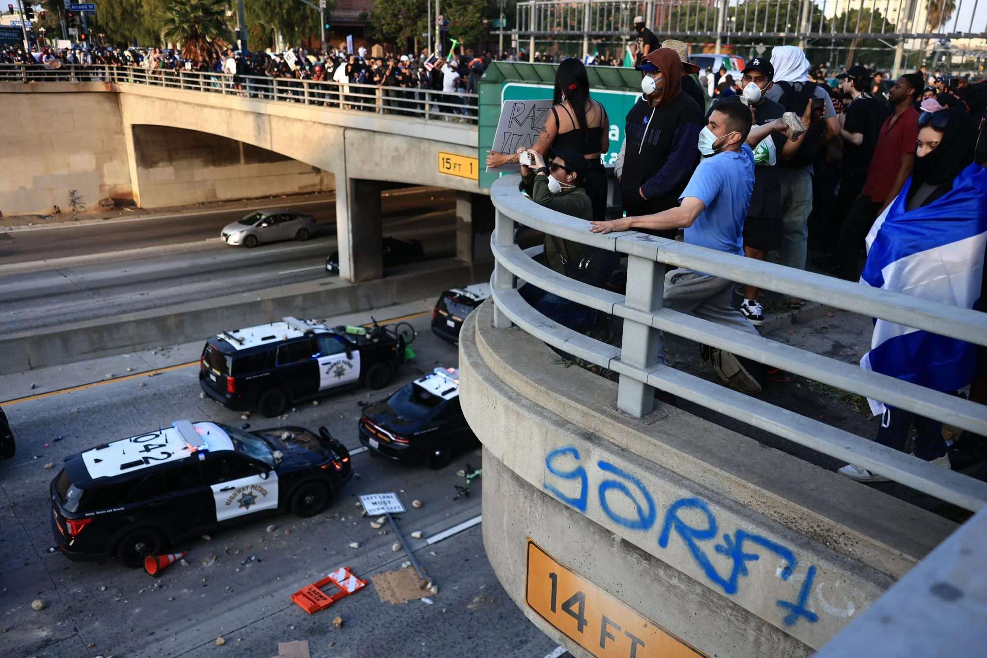  A man throws a rock toward police vehicles during a protest against federal immigration sweeps, in downtown Los Angeles, California. 