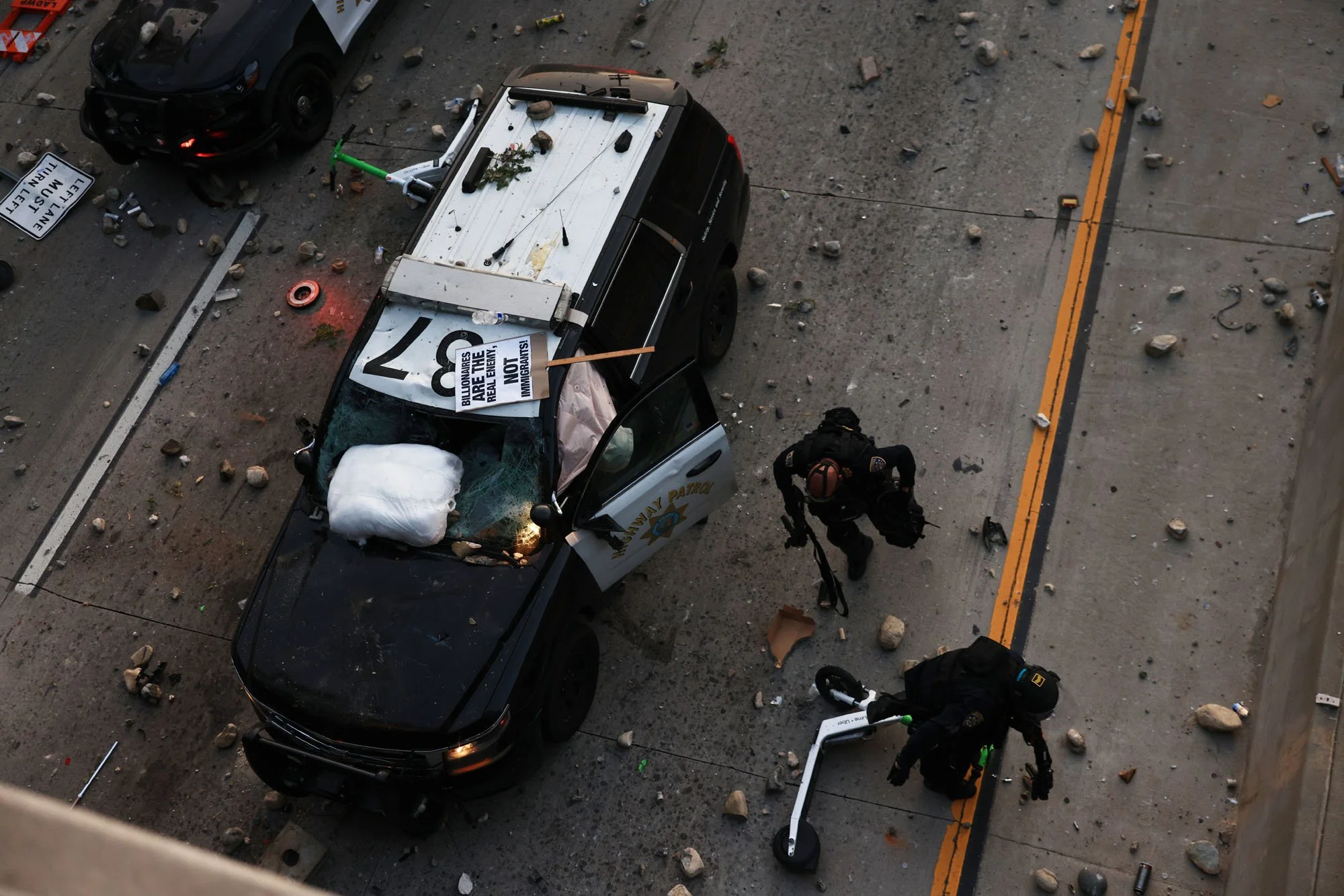  Los Angeles Police officers run for safety during a protest against federal immigration sweeps, in downtown Los Angeles, California. 