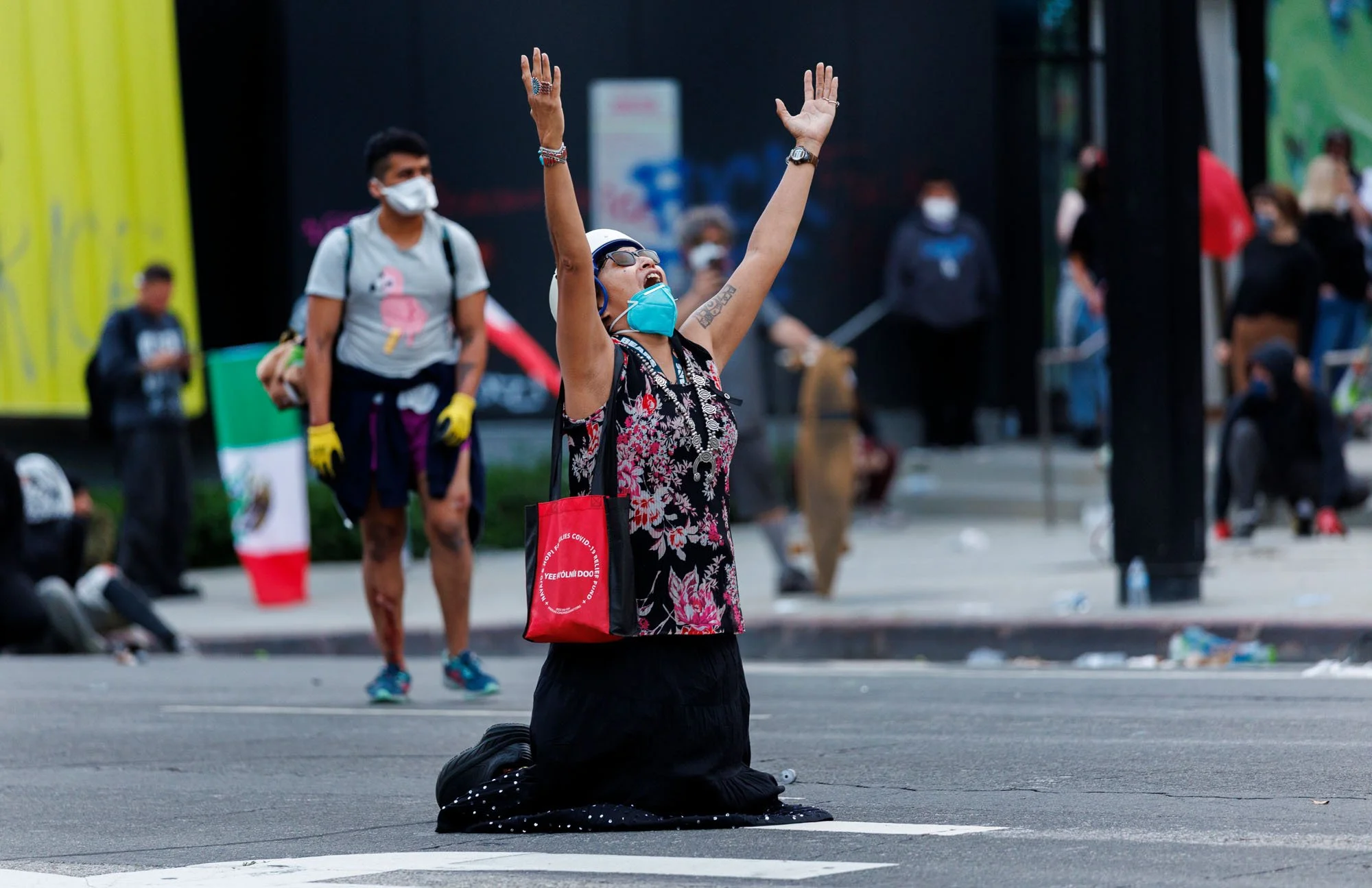  LOS ANGELES, CA -  A protester prays in the the middle of the street near City Hall as Los Angeles Police officers  advance on demonstrators  downtown  during a protest against immigration raids on June 8, 2025 in Los Angeles, California. 