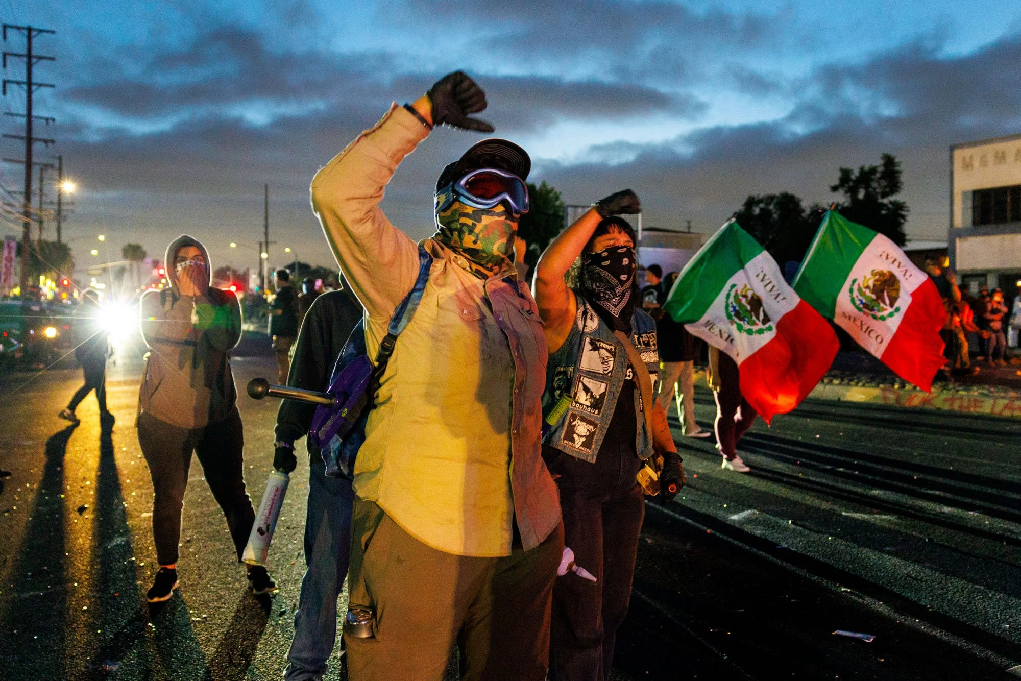 COMPTON, CA - Wearing face protection, demonstrators march towards law enforcement while protesting the ICE immigration raids on June 7, 2025 in Compton, California. 