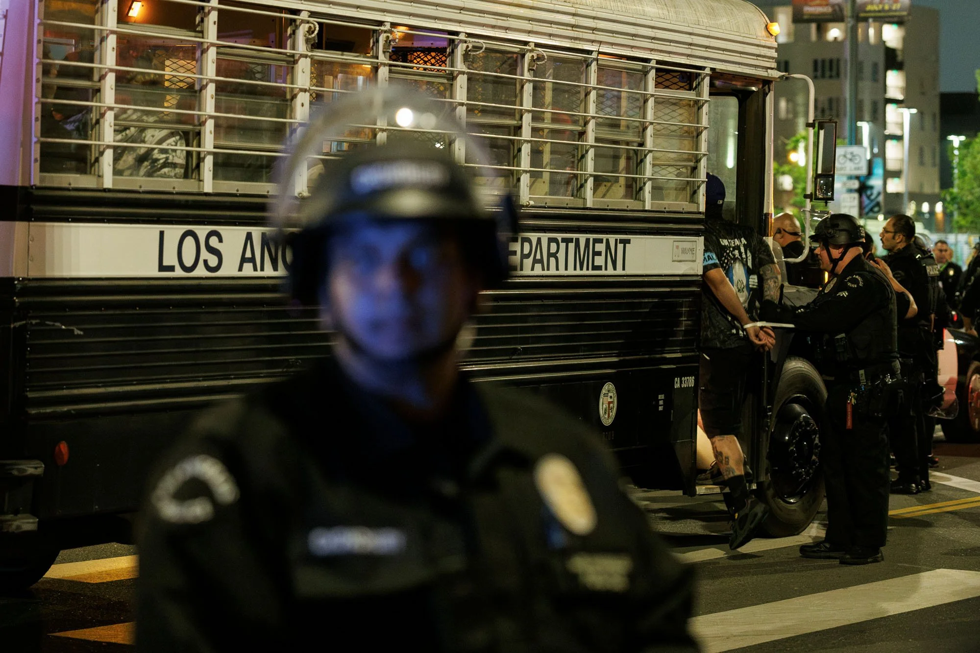  LOS ANGELES, CA -  Protesters with zip ties on their wrists  are loaded onto a bus after being arrested for defying the 8PM curfew and for failing to disperse on Alameda Street during anti-immigration raid protests  on June 12, 2025 in Los Angeles, 