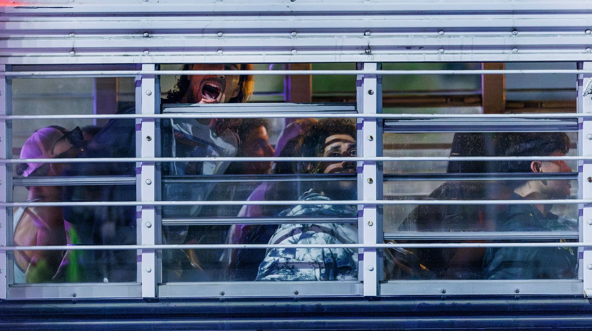  LOS ANGELES, CA -  An arrested protester yells thorough an open window while inside a Los Angeles Police Department bus filled with arrestees for defying the 8PM curfew and for failing to disperse on Alameda Street during anti-immigration raid prote