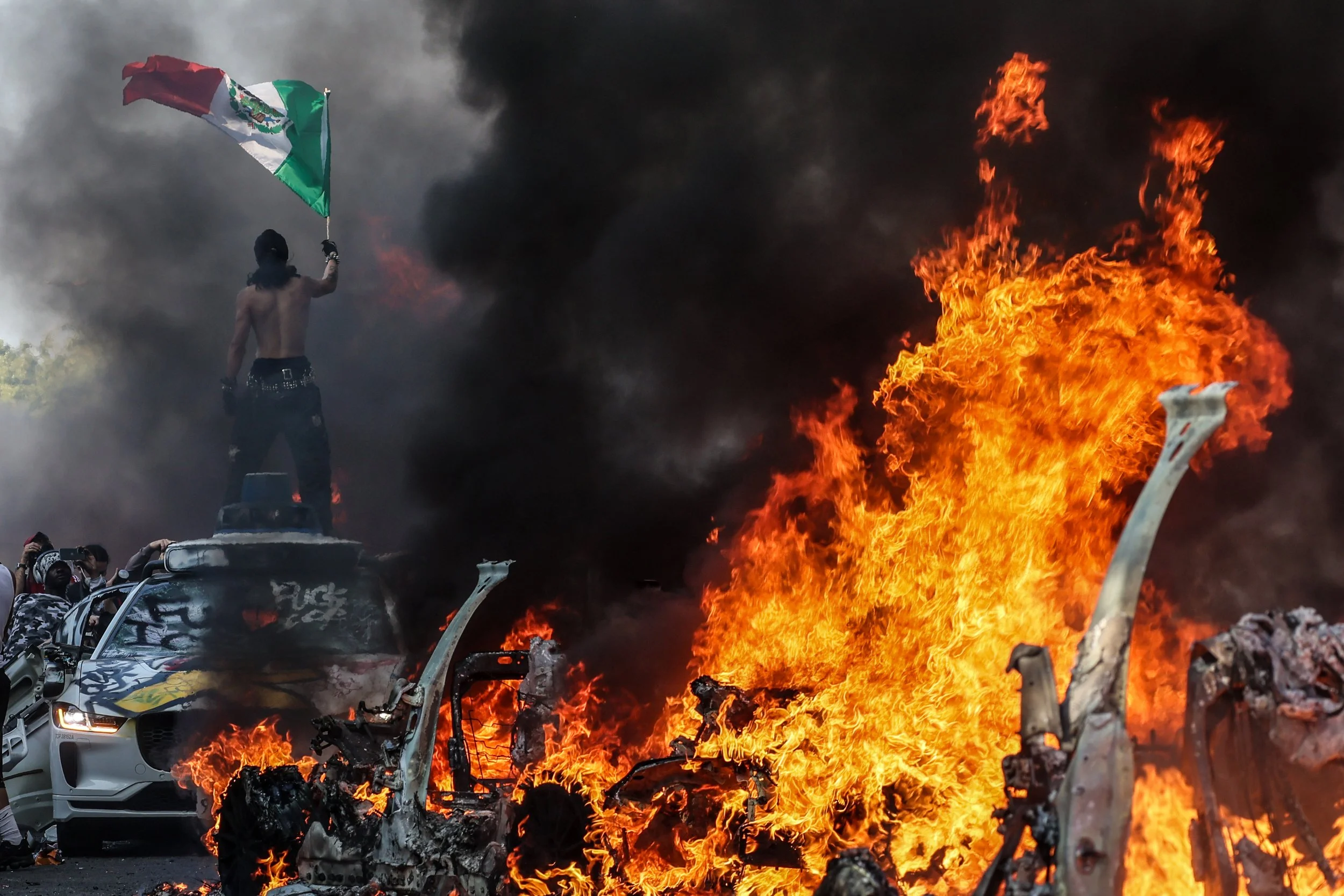  Los Angeles, CA, Sunday, June 8, 2025 - Waymo taxis burn on Los Angeles St.  as thousands of protesters take to the streets to protest ICE immigration raids throughout the city.   