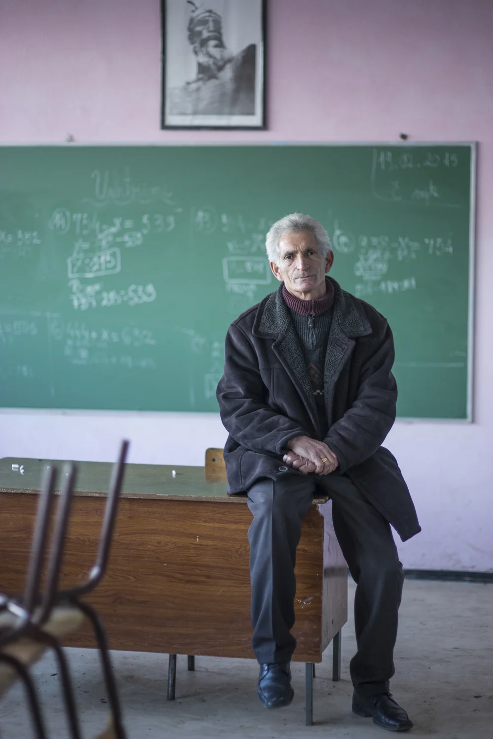 Teacher Enver I( 61) sitting in an empty classroom after school