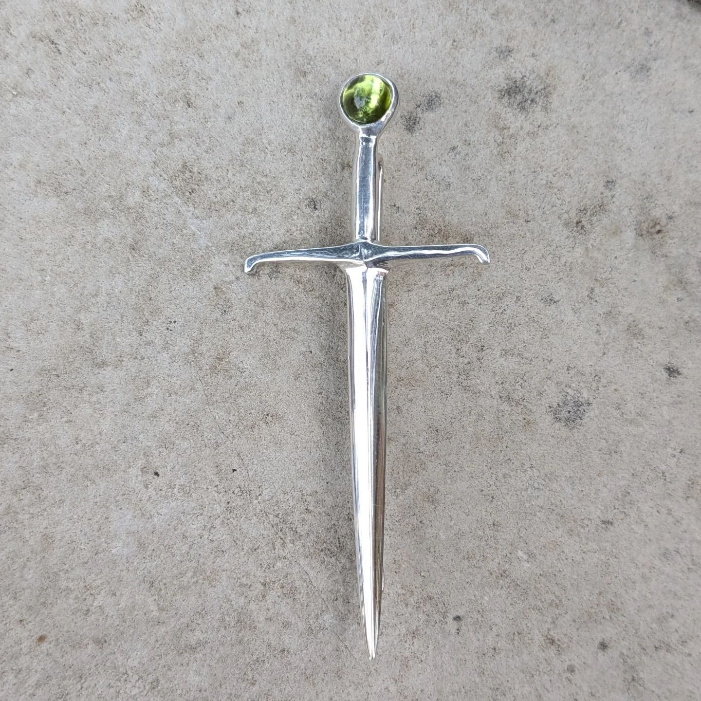 My Fiore longsword brooch, set with a cabochon peridot. Love that pop of colour! Don't forget to come join us for our tiny perfect pop up next Saturday  at 640 pape Ave, 12/6pm. #medieval #longsword #fiore #hema #brooch #mensjewelry #lapelpin