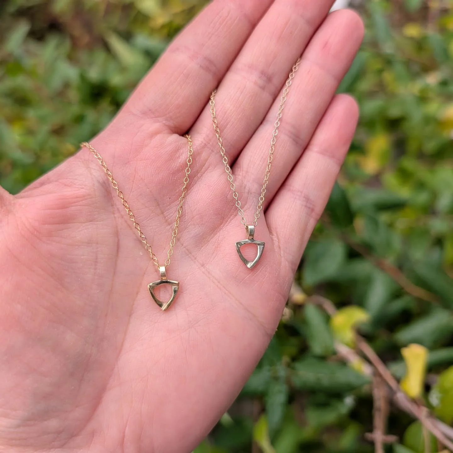 Yellow and rose gold plated tiny shield maiden pendants. 
These are a delicate reminder of feminine strength! 
#daintyjewelry #shieldmaiden #daintynecklace