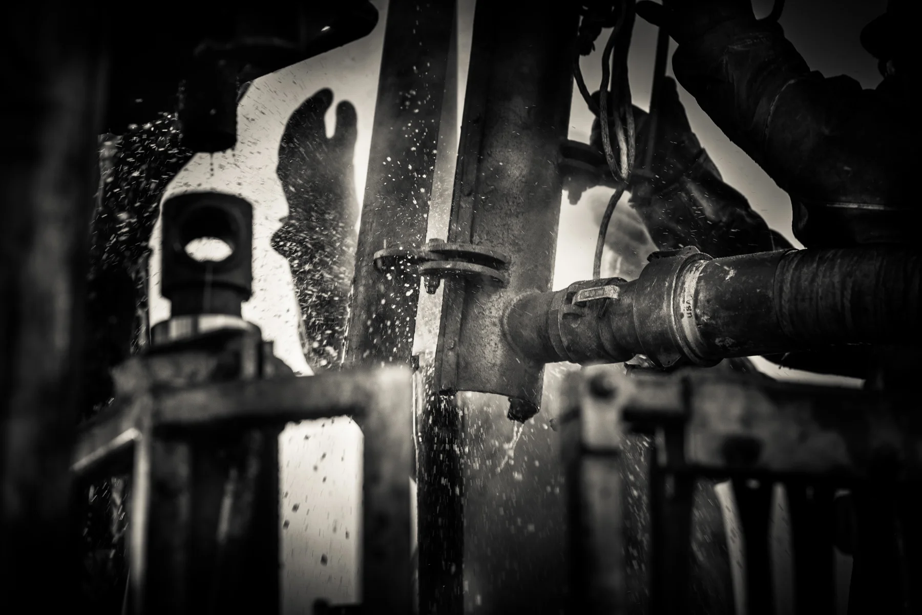 As workers remove the last of four miles of drill pipe, hot salt water released from deep in the earth blasts out of the oil well and douses the crew of three men confined to a basket 40 feet above the ground. The entire crew is especially vigilant during this, the most dangerous part of the fracking process. A false move could send the highly pressured drill pipe shooting hundreds of feet into the air, destroying equipment and killing men as it returns to the ground.