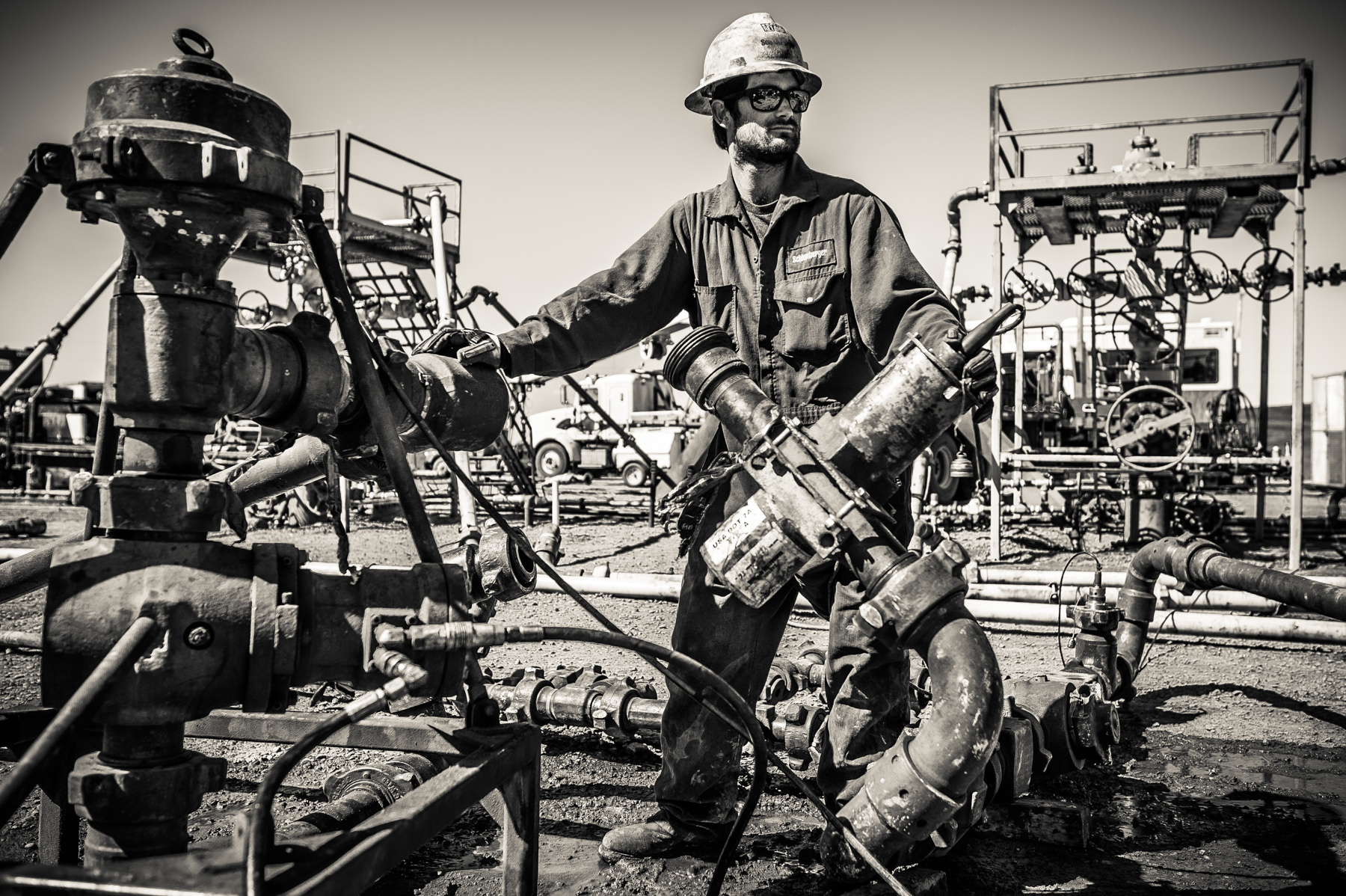  A worker at a frack site, aka a "fracker," installing part of the massive plumbing project that will lead to the fracking of this oil well.&nbsp; 
