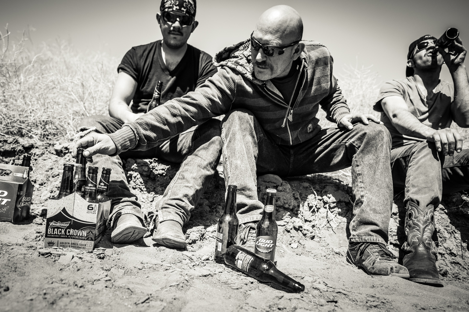  This all Hispanic workover crew enjoys their brief time off by drinking beer on the edge of their man camp. To discourage the otherwise bored men from drinking, their shifts begin at midnight and end at noon. The bars are not open when their shifts 