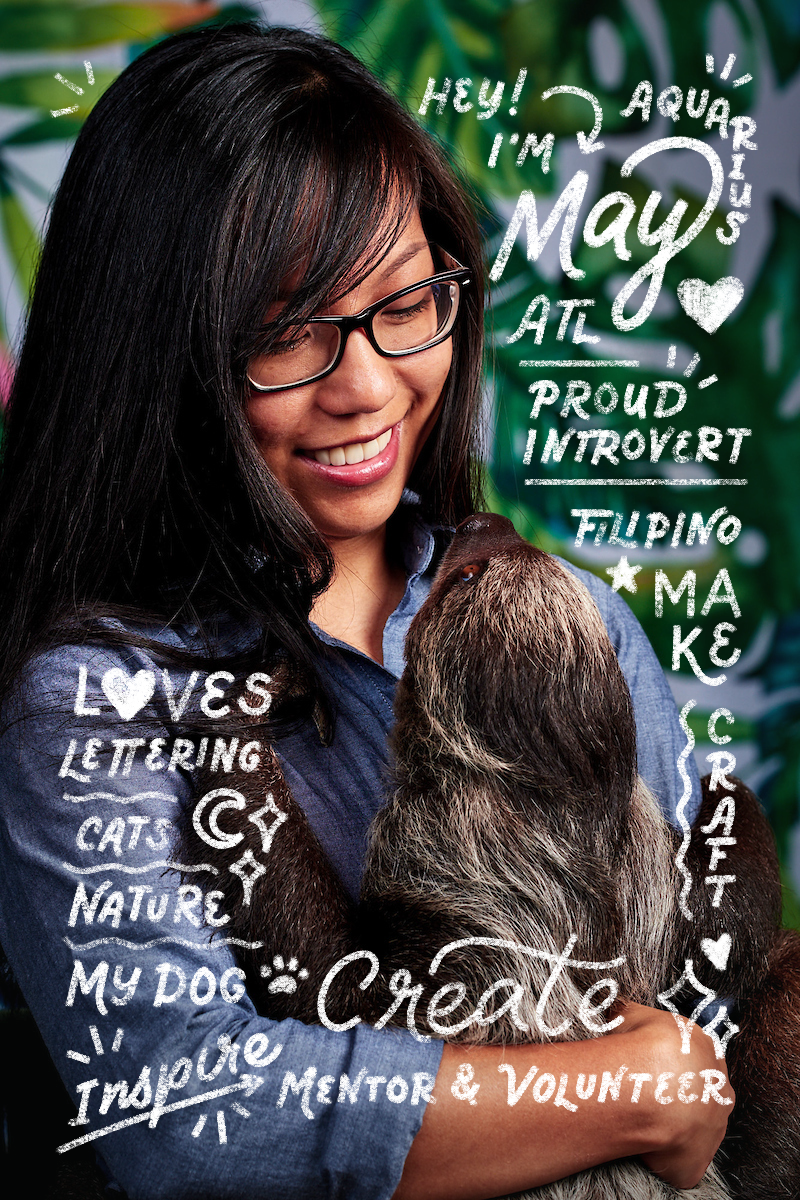 A woman with glasses smiling and holding a baby sloth, surrounded by white handwritten text about her interests and personality, with a green leafy backdrop.