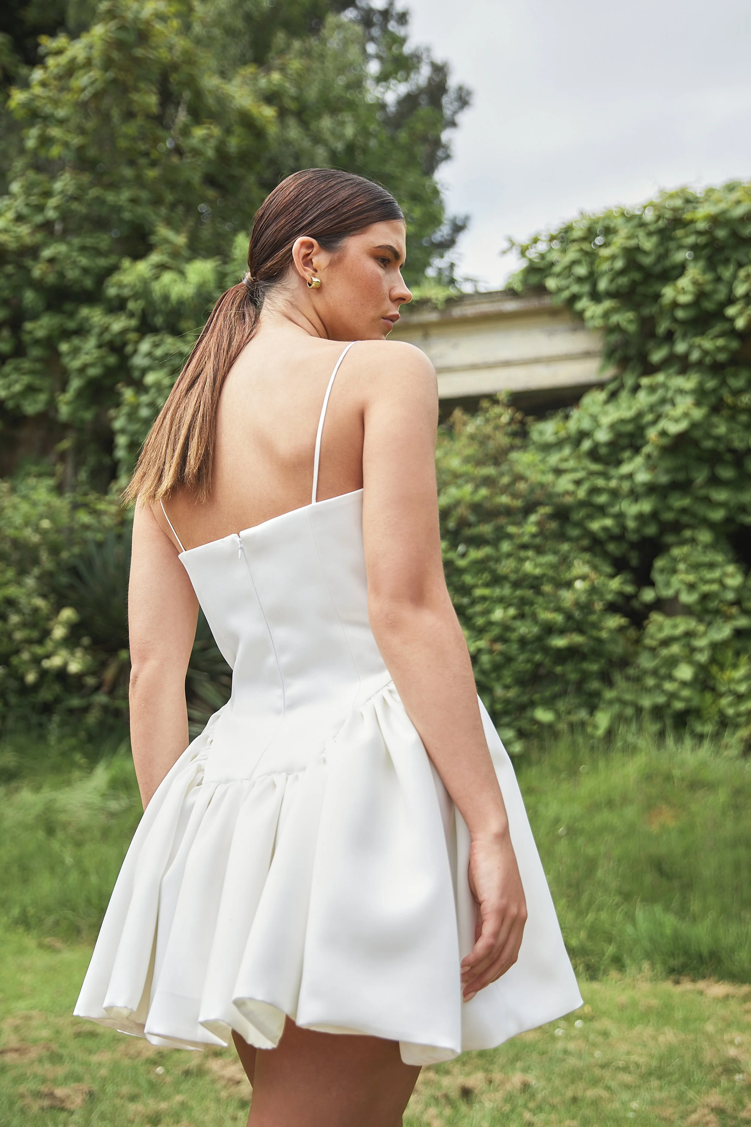 Where maximal gathers and volume meets minimal necklines and detailing. The Delphine Mini features an extended dropped waist bodice, cut to highlight the feminine form and mini gathered skirt. Constructed in buttery soft duchess satin, with the inter