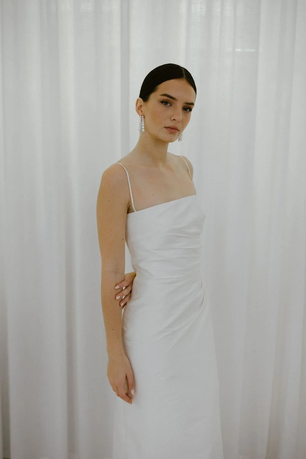 The perfect reception or civil ceremony piece. The She Midi features side waist pleating, an above ankle hemline and side split. Style alone or layer with our sleeve / bow additions for an interchangeable look. Fastens with concealed side zip allowin