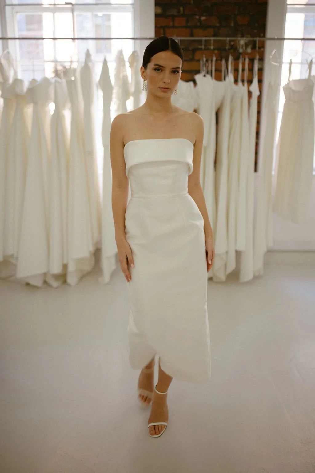Effortlessly elegant, the Alexa Midi is a modern bridal silhouette crafted in our signature Mikado. A supportive boned internal bodice and refined bias band neckline create a beautifully structured fit, while the sleek column skirt offers clean, unde
