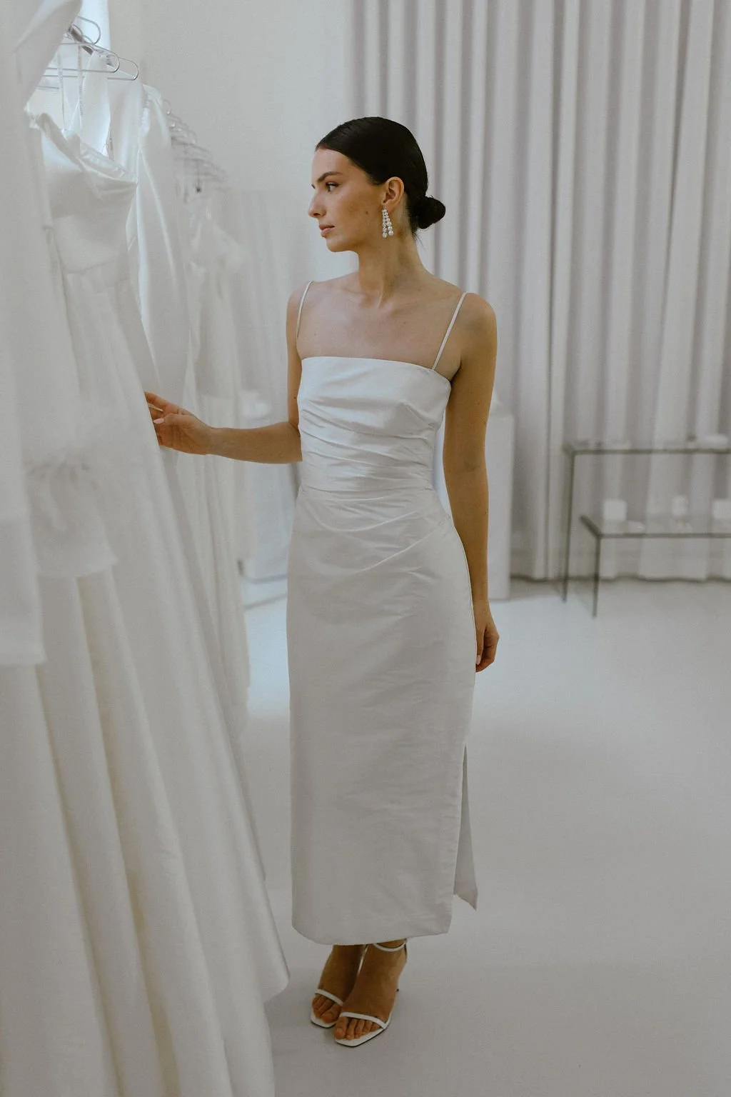 The perfect reception or civil ceremony piece. The She Midi features side waist pleating, an above ankle hemline and side split. Style alone or layer with our sleeve / bow additions for an interchangeable look. Fastens with concealed side zip allowin