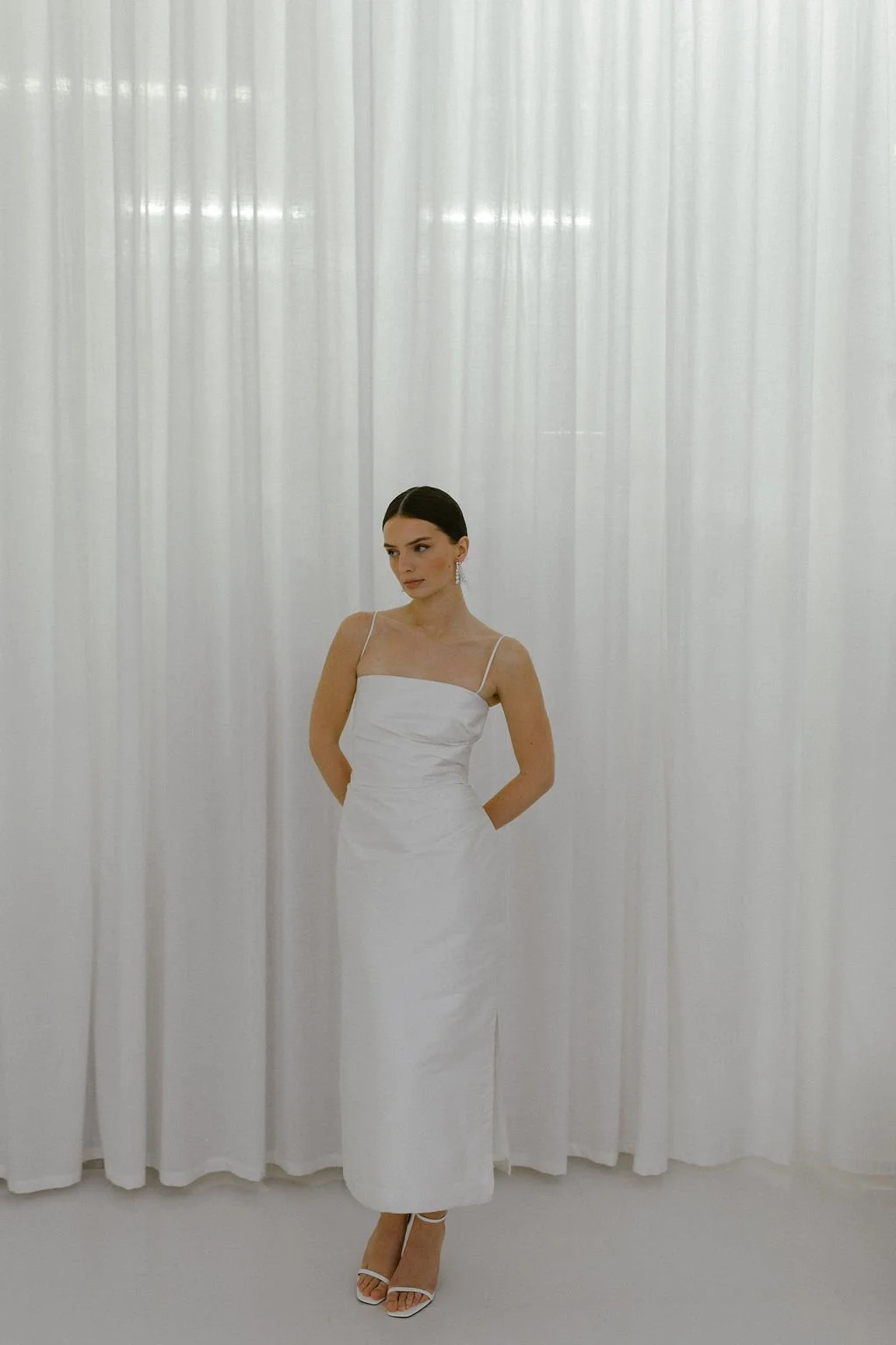 The perfect reception or civil ceremony piece. The She Midi features side waist pleating, an above ankle hemline and side split. Style alone or layer with our sleeve / bow additions for an interchangeable look. Fastens with concealed side zip allowin