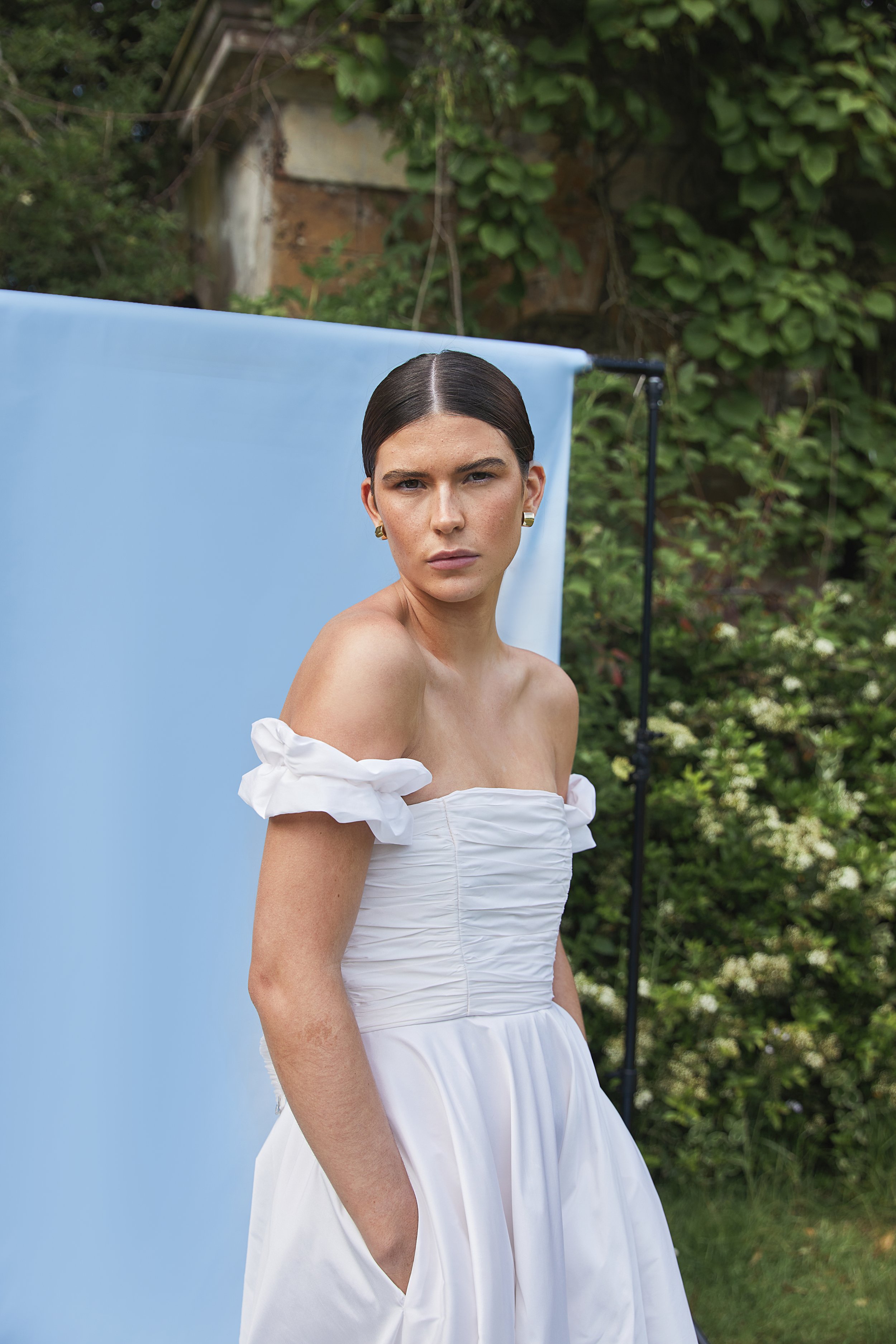 Tiffany wedding dress by Jessica Bennett. Featuring hand-pleated taffeta sits over an internal boned corset giving structure and support. Paired with full circular skirt and pockets. 