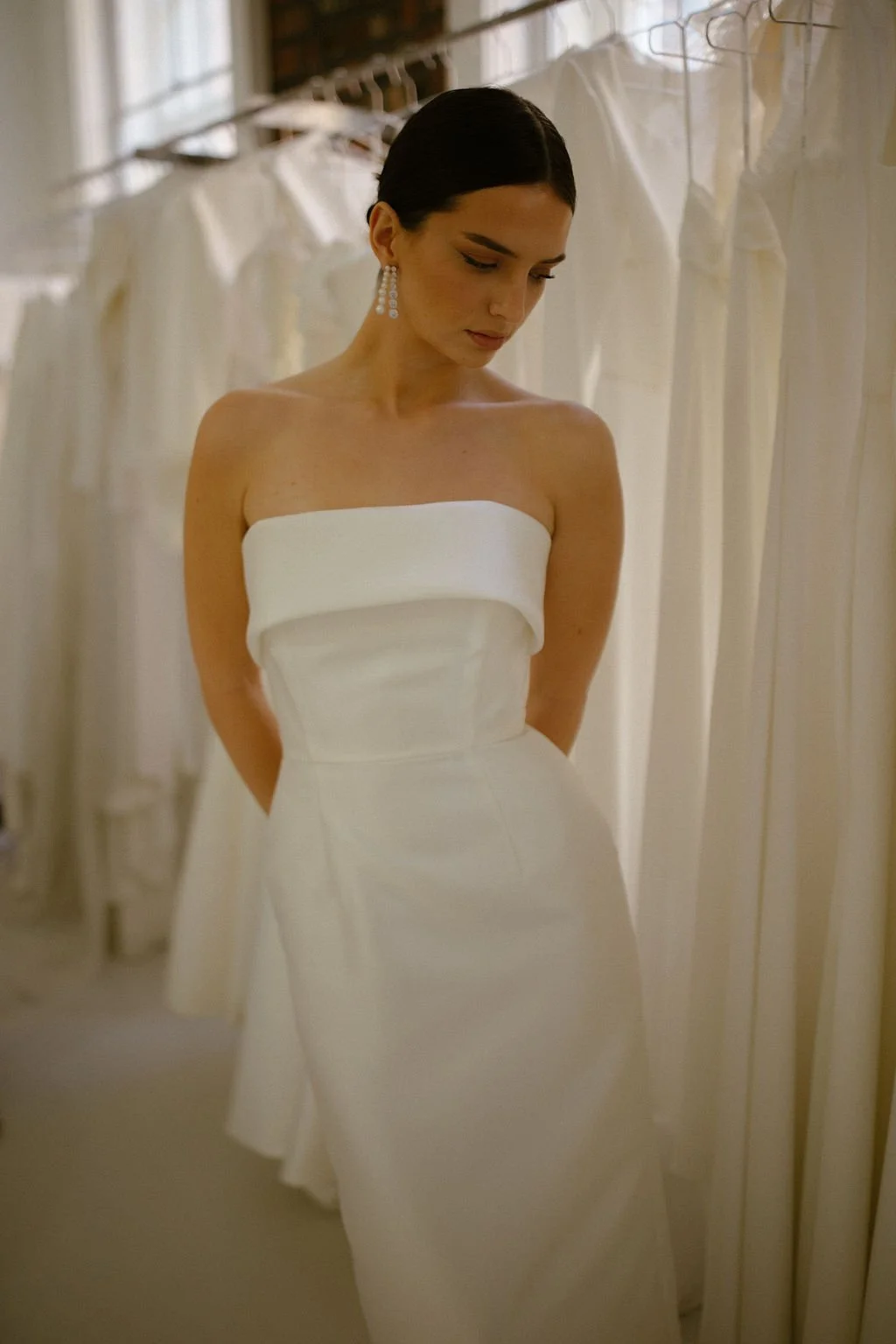 Effortlessly elegant, the Alexa Midi is a modern bridal silhouette crafted in our signature Mikado. A supportive boned internal bodice and refined bias band neckline create a beautifully structured fit, while the sleek column skirt offers clean, unde