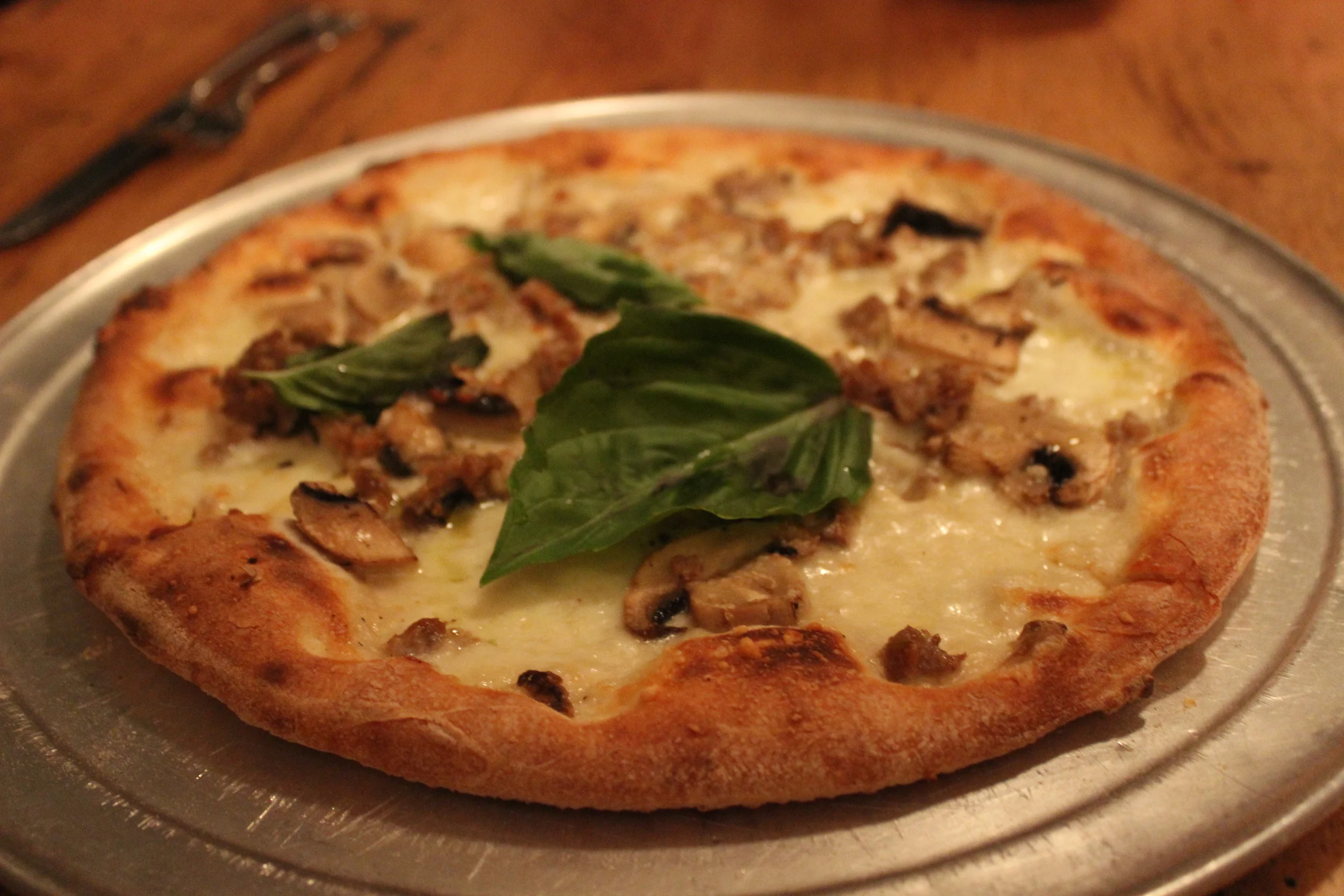 Boscaiola Pizza - topped with mozzarella, sausage, mushrooms and basil!