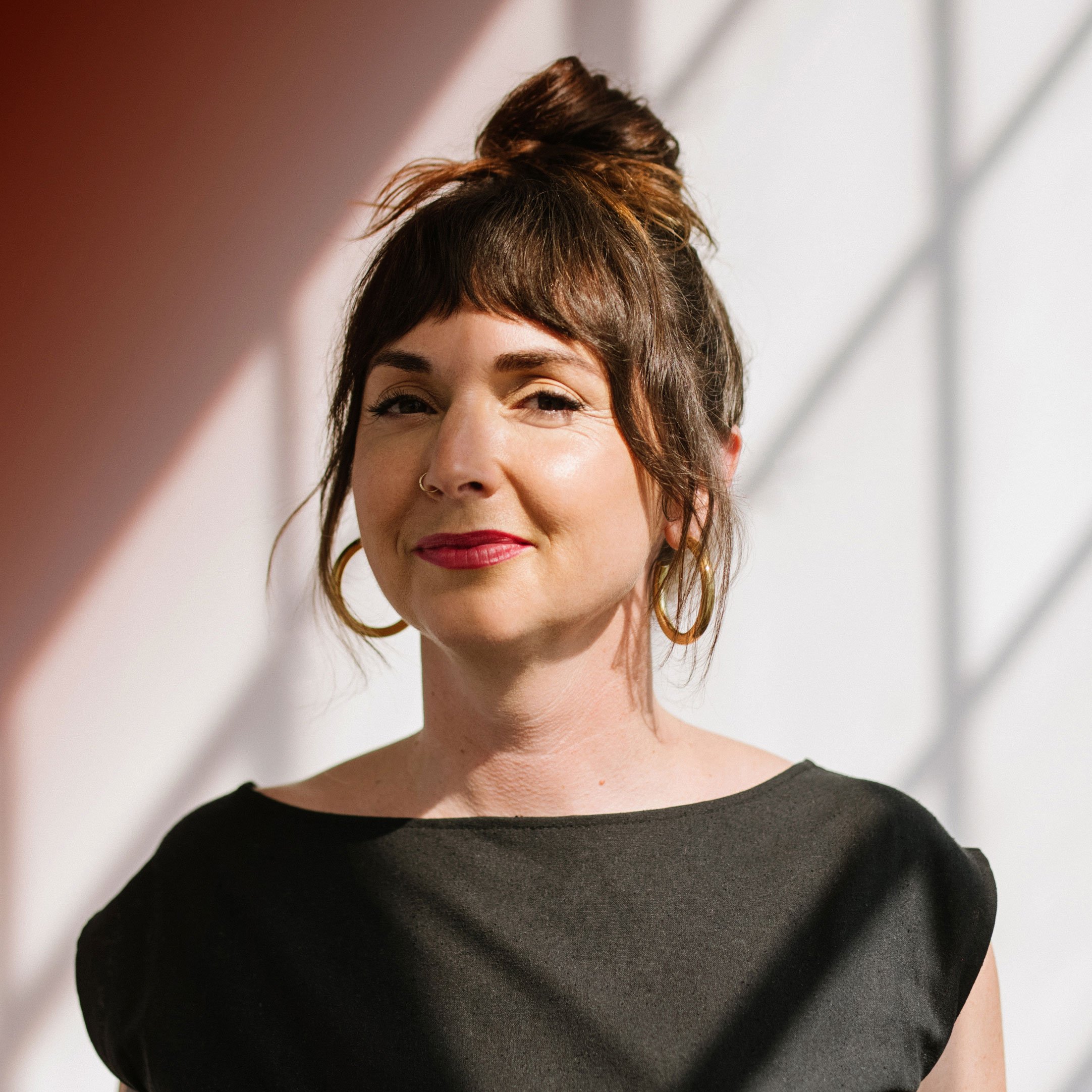 Ariana Wolf, Co-founder and Brand Strategist at Flight Design Co., smiling in a professional portrait setting.