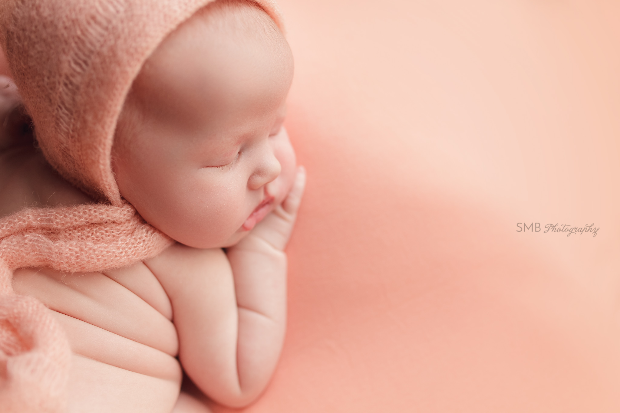 Newborn girl on peach blanket closeup