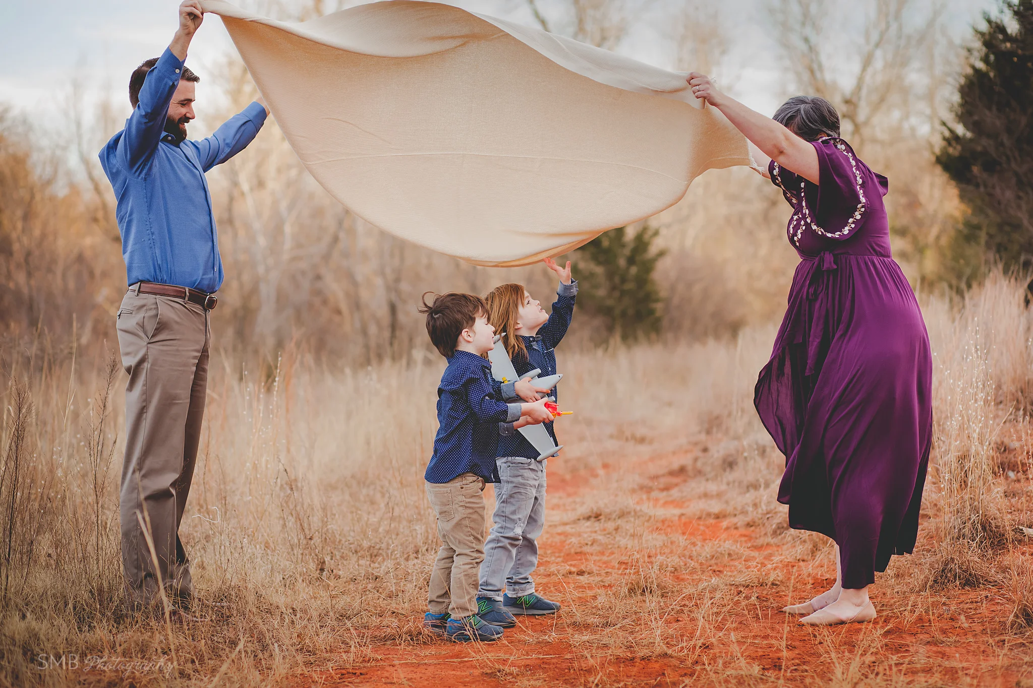 Mom and Dad throwing blanket up for boys to run under