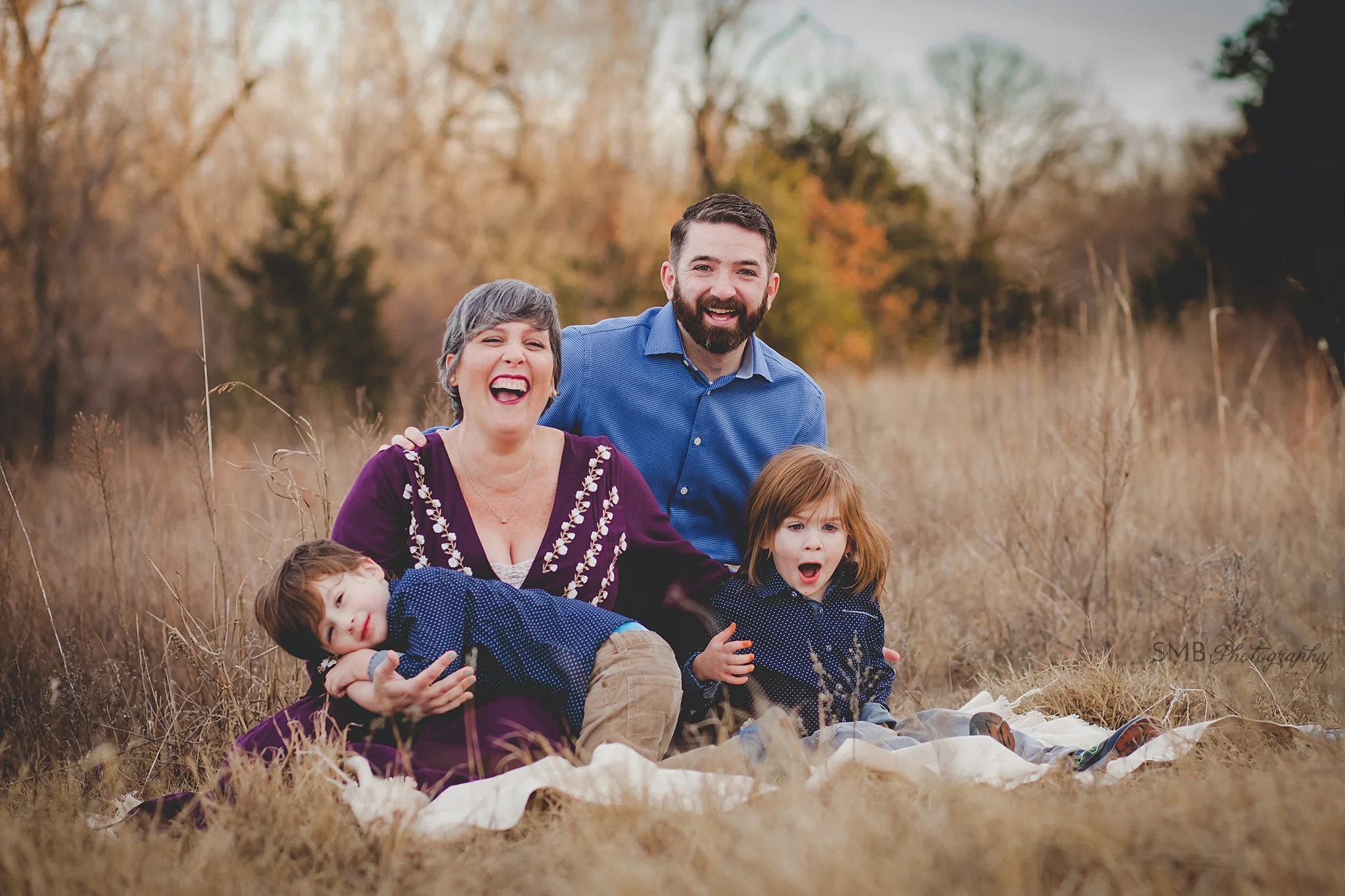 Family smiling together sitting in field