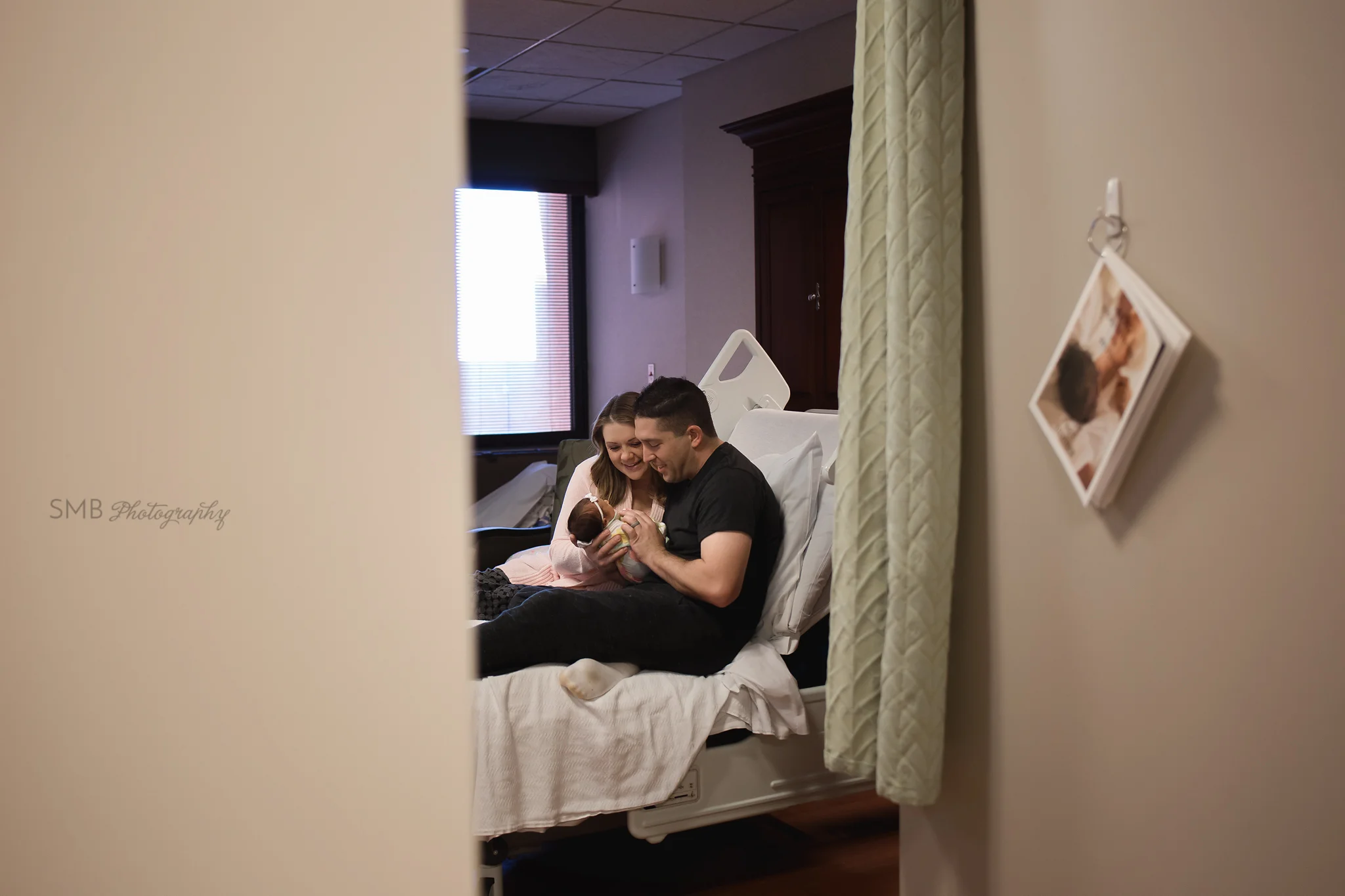 Mom, Dad and newborn baby girl in hospital bed