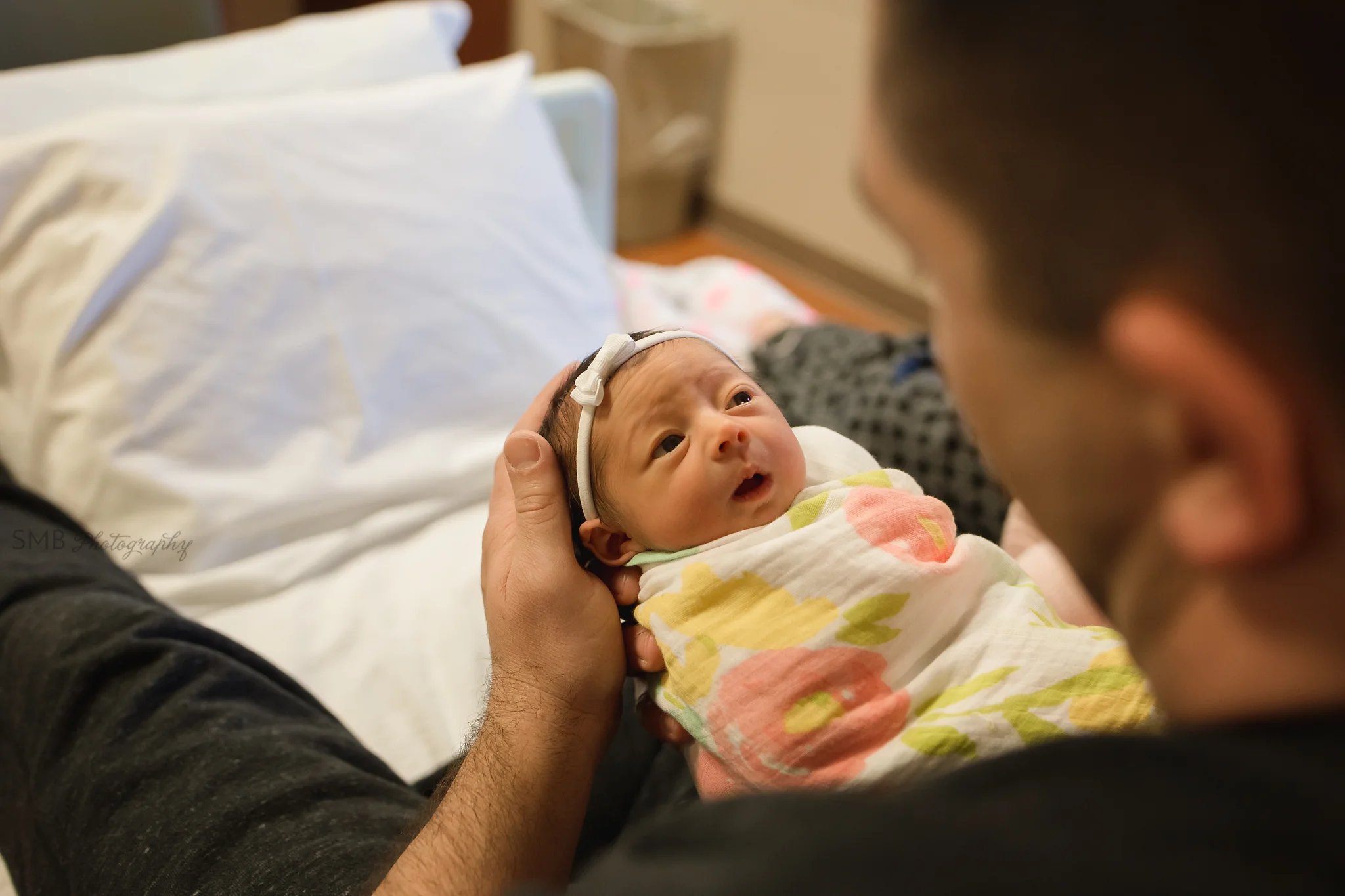 Newborn girl looking at Mom & Dad