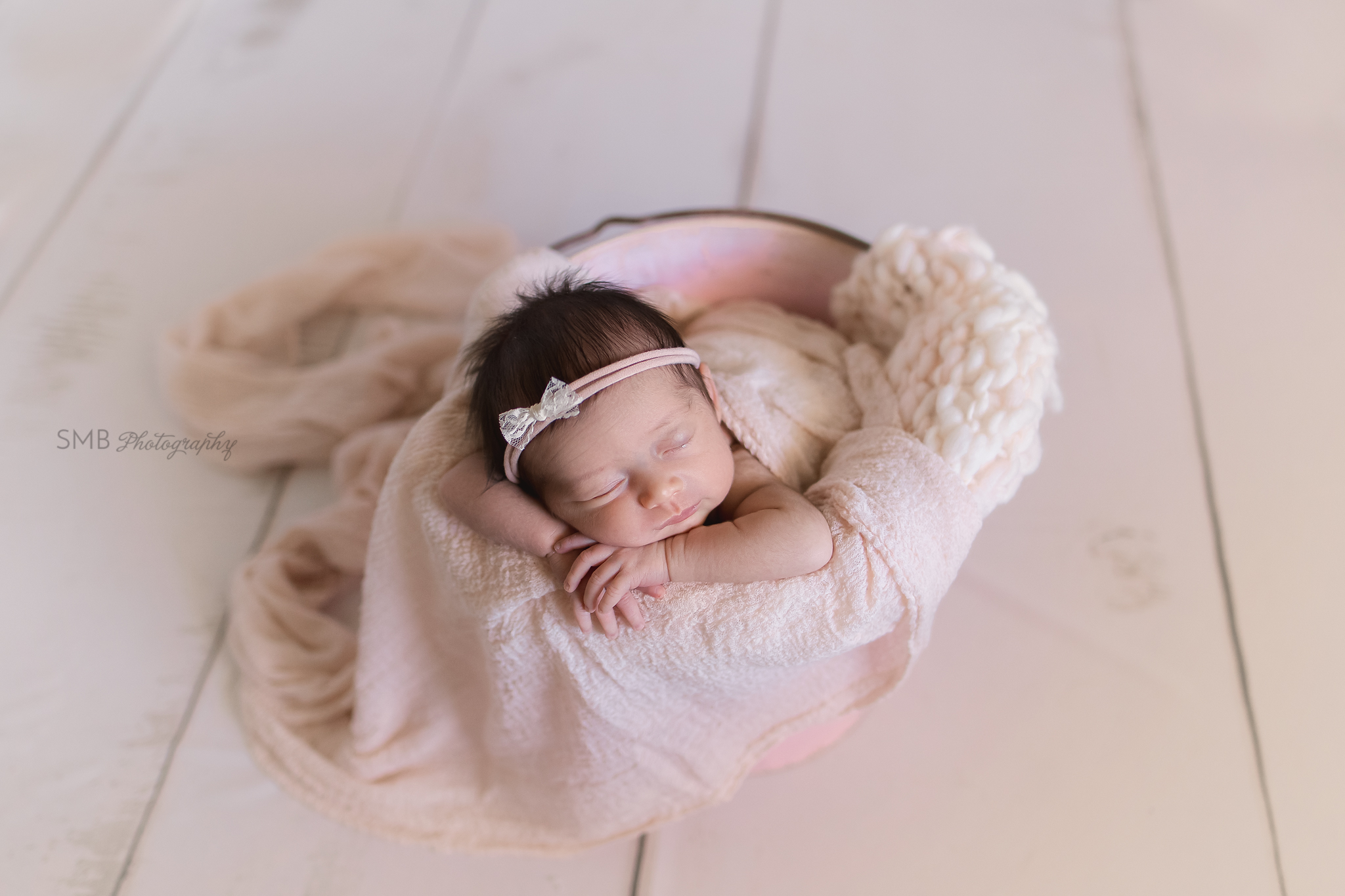 Newborn girl in pink bucket