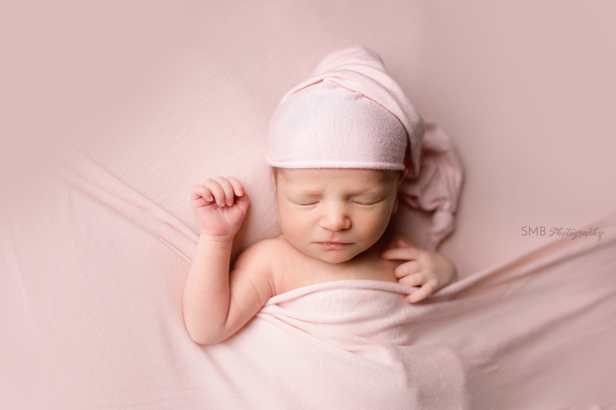 Newborn girl wearing pink sleepy cap