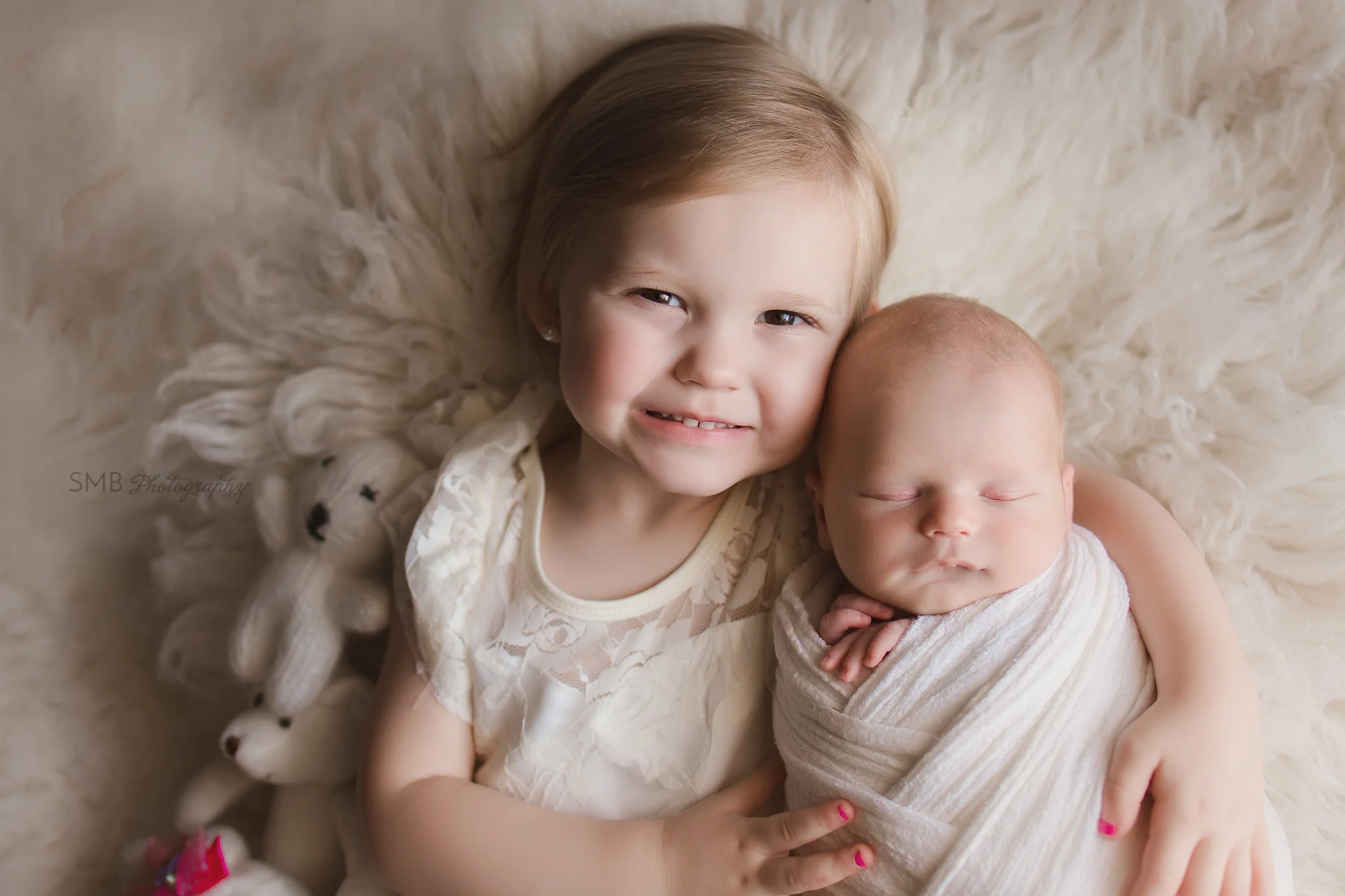Toddler girl cuddling baby brother