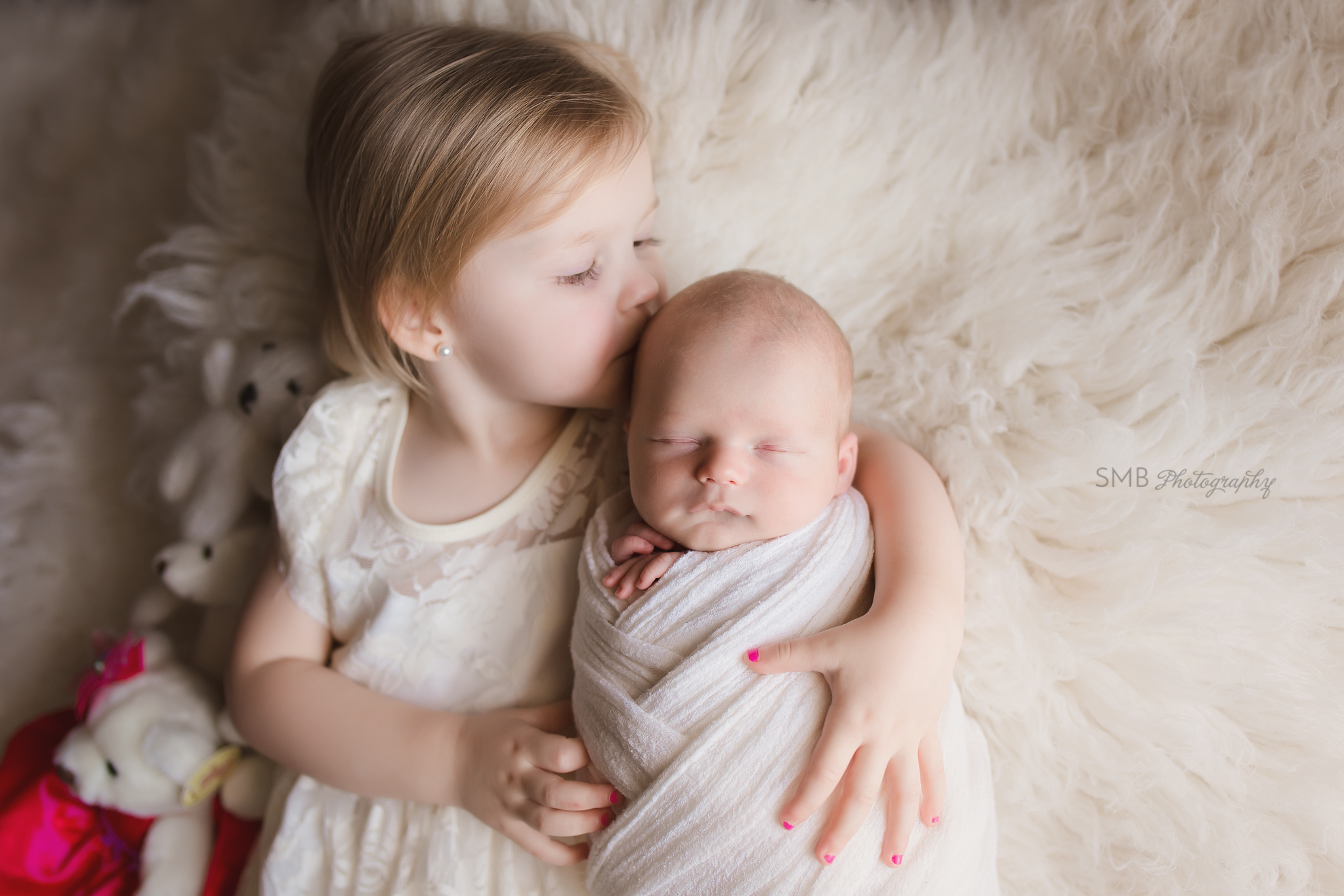 Big sister kissing newborn brother