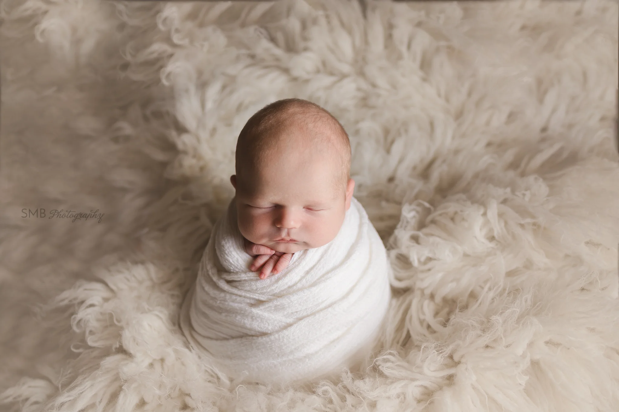 Newborn baby boy in potato sack wrap