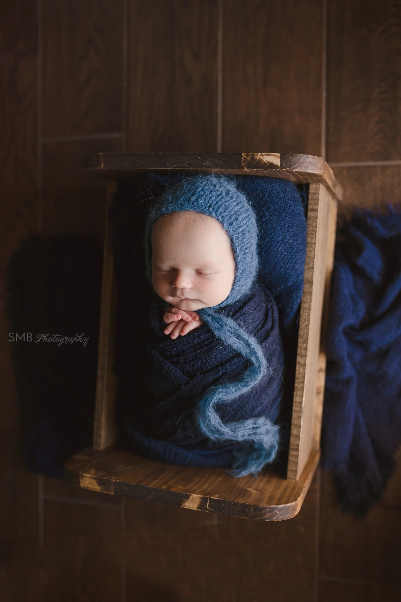 Baby boy in cradle wrapped in navy blue