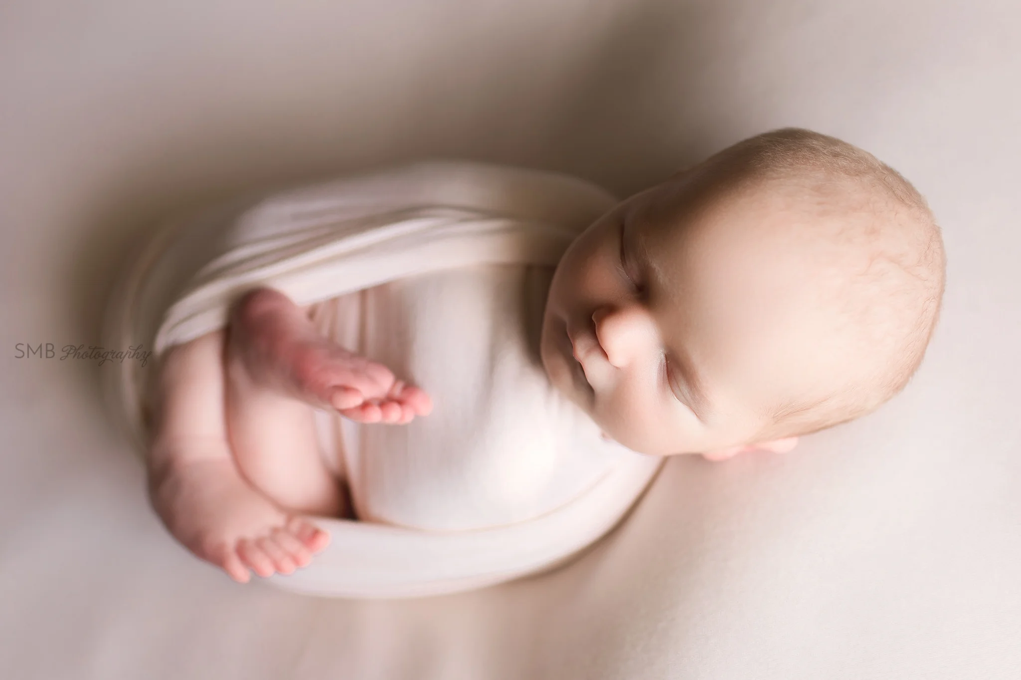 Baby boy wrapped on skintone colored fabric