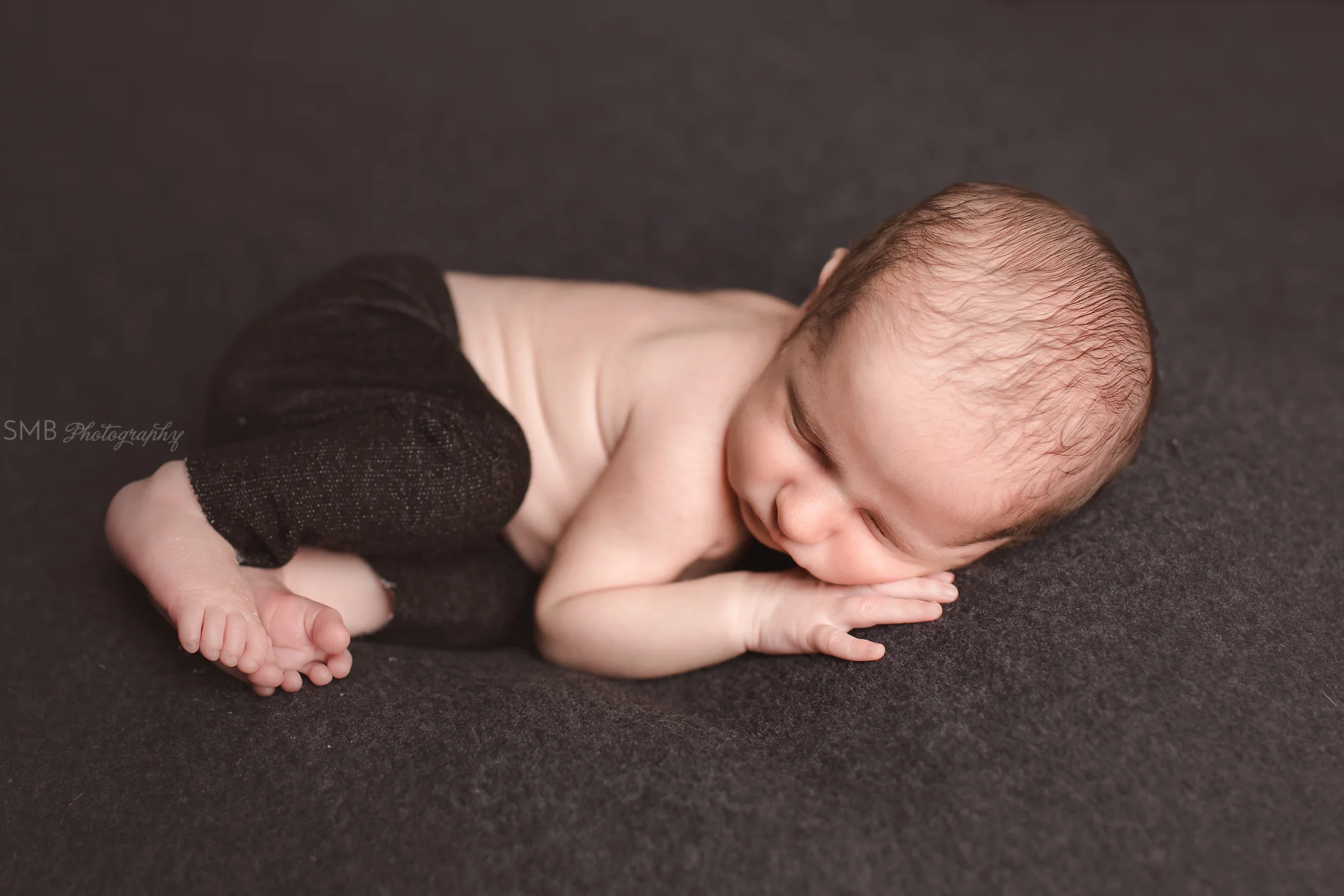 Newborn baby boy laying on his side