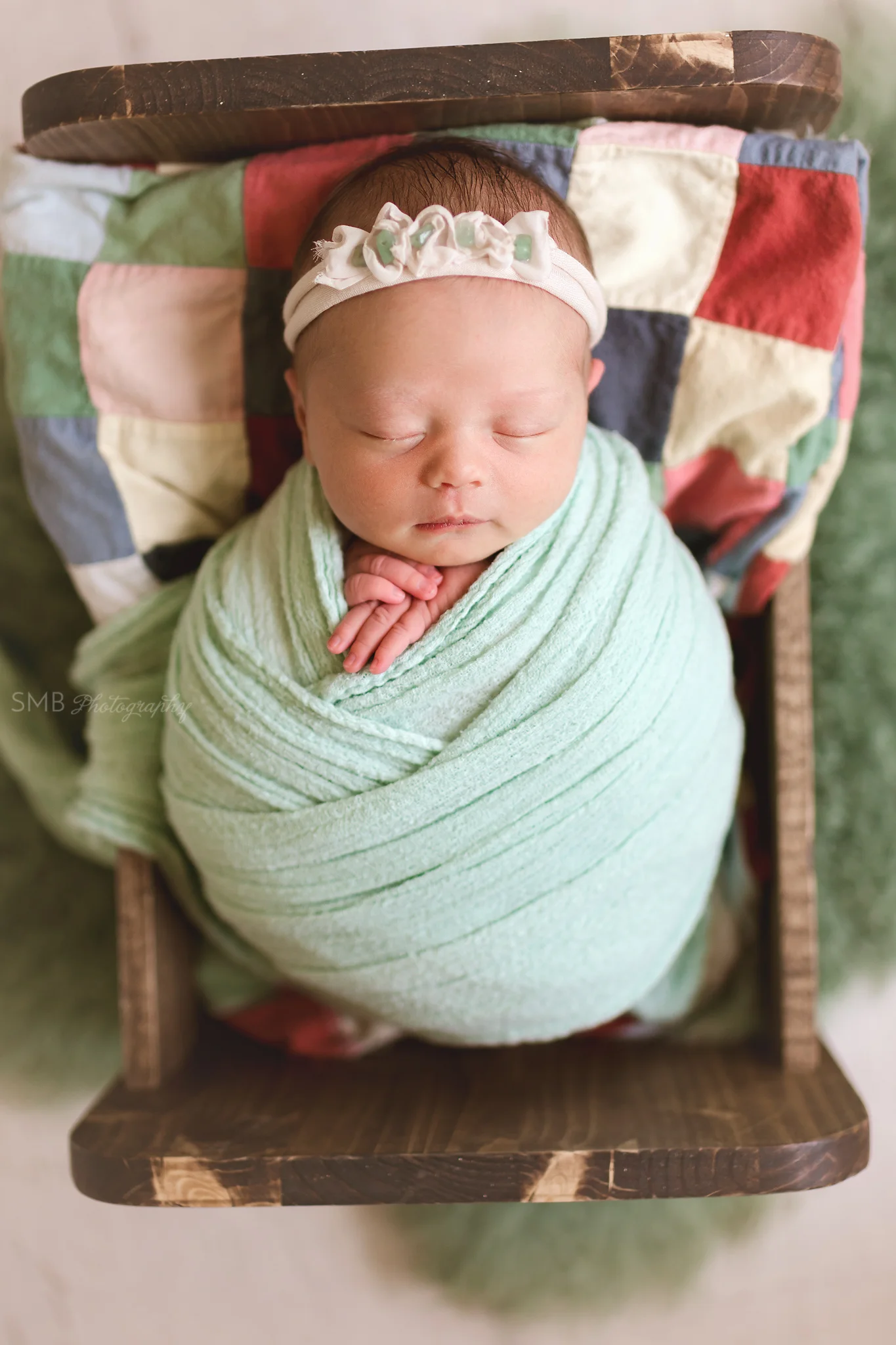 Baby wrapped in wood cradle