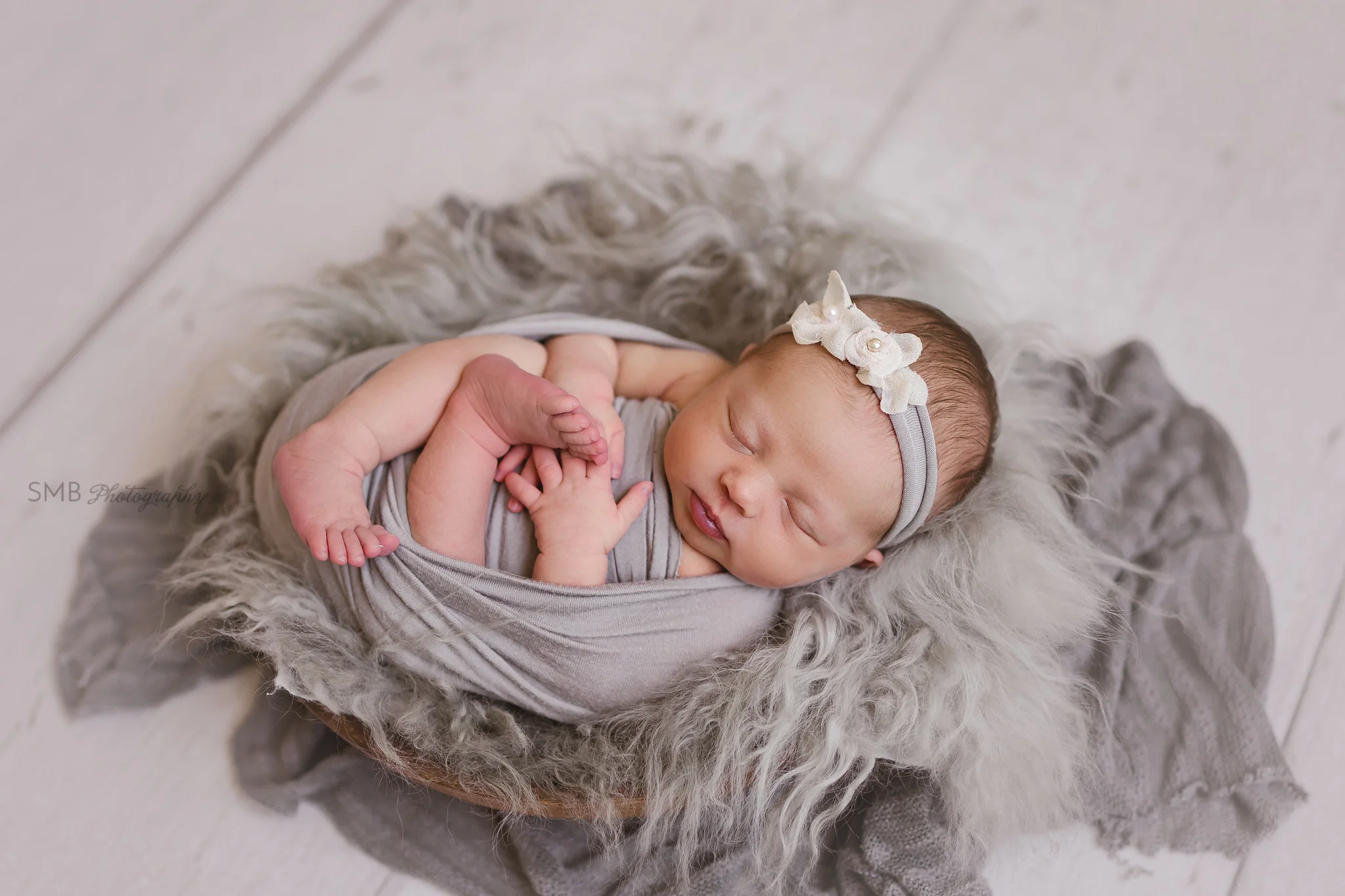 Baby wrapped in wood bowl