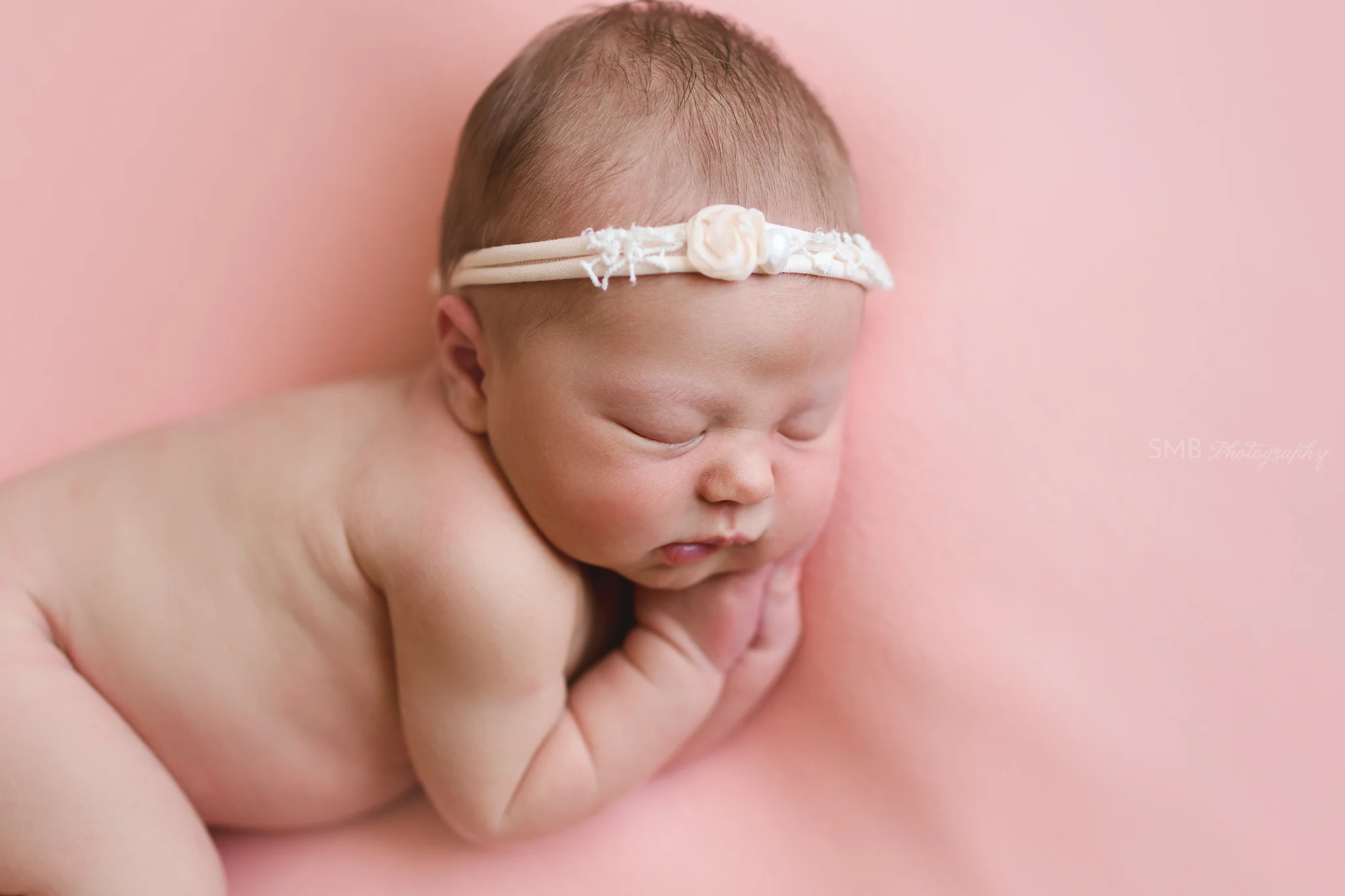 Baby girl profile portrait on peach backdrop