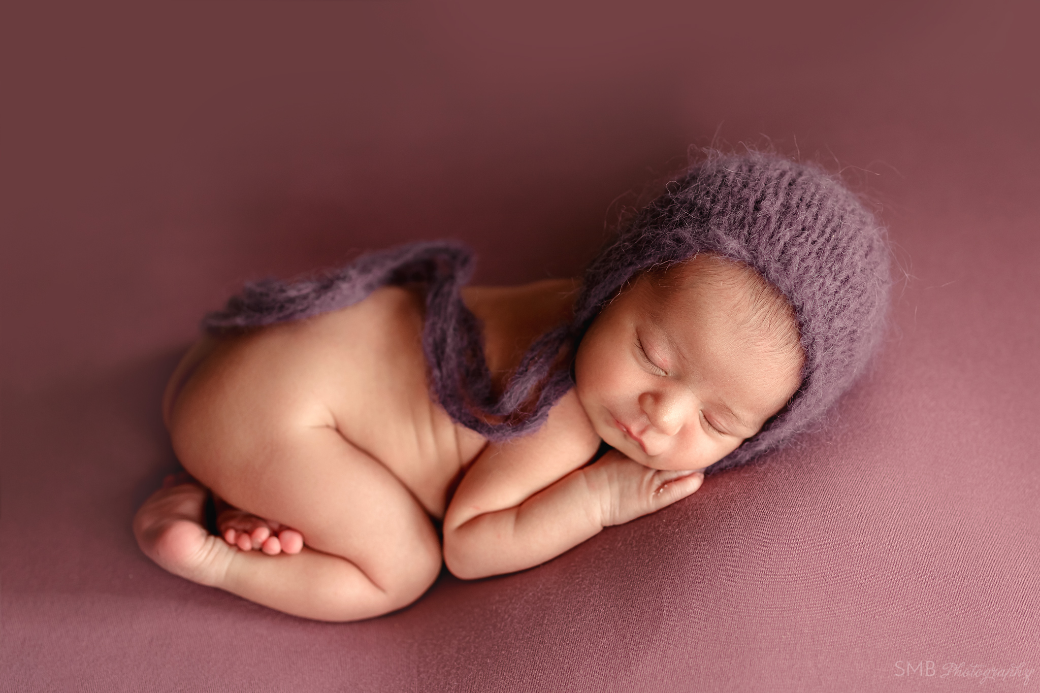 Baby girl wearing purple fuzzy bonnet