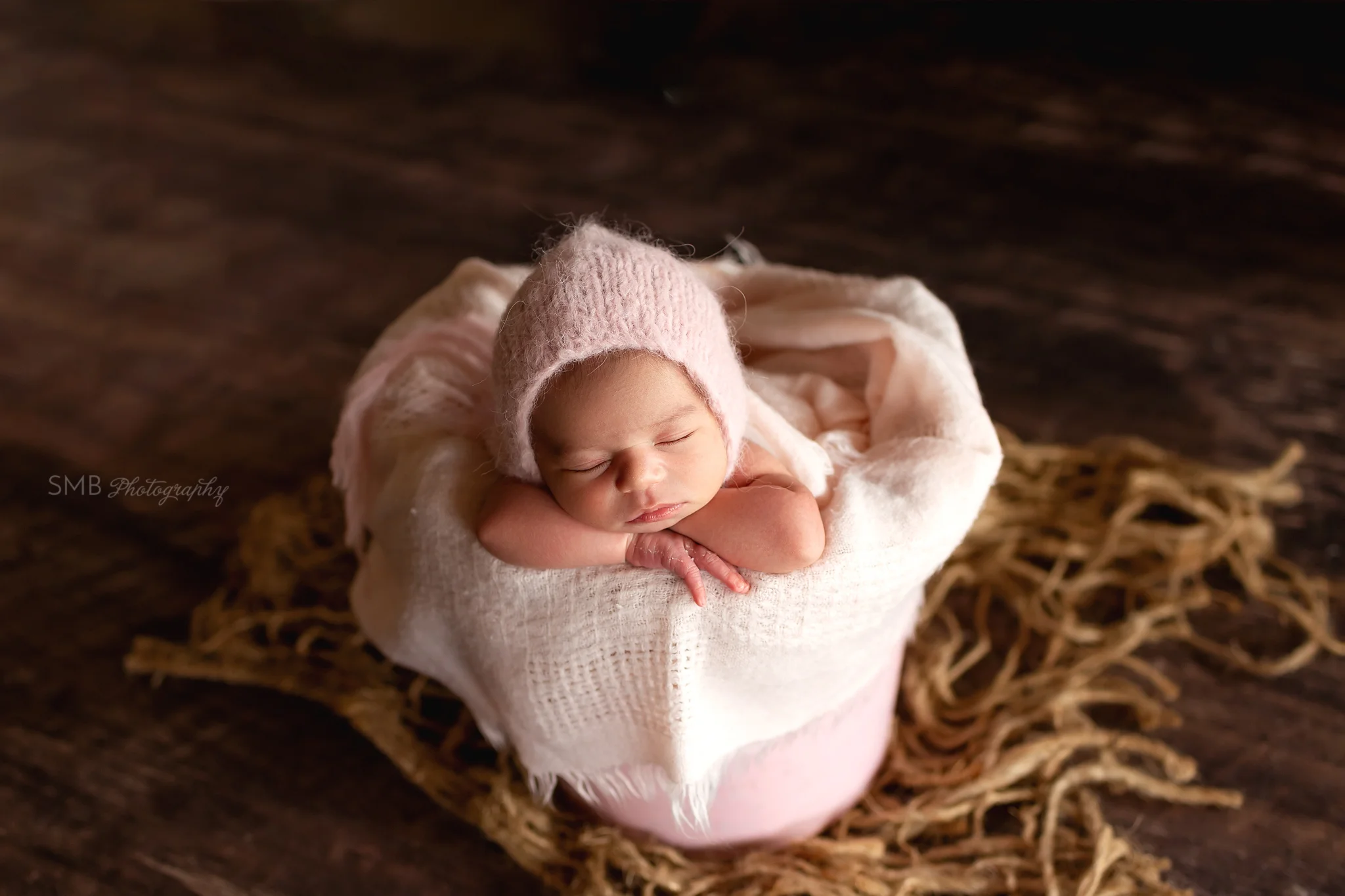 Baby girl sleeping in pink bucket