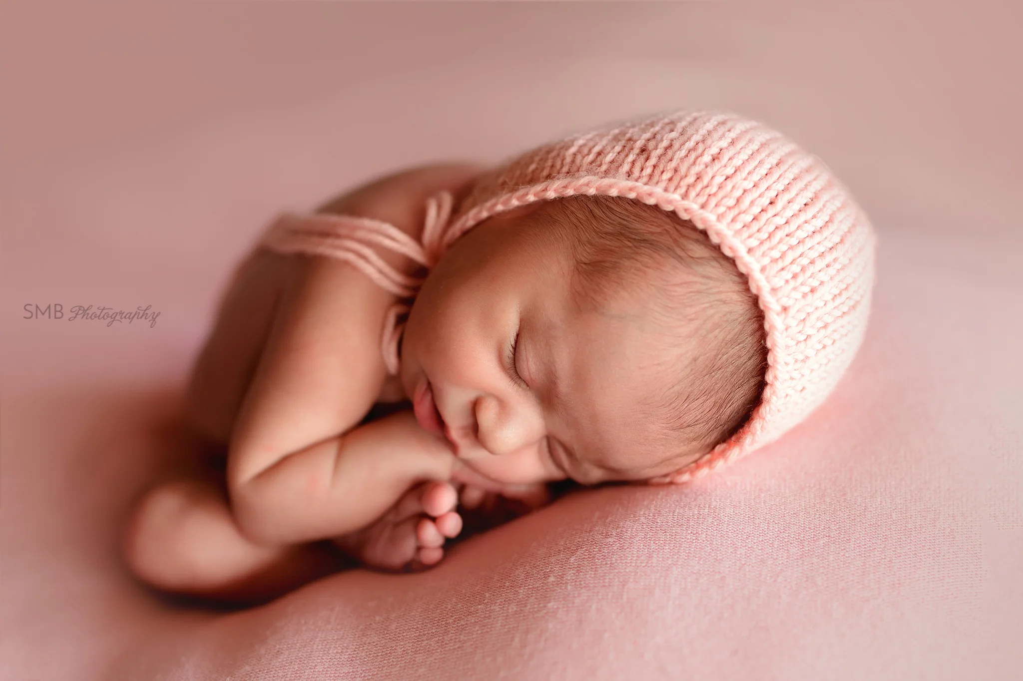 Newborn curled in womb like pose
