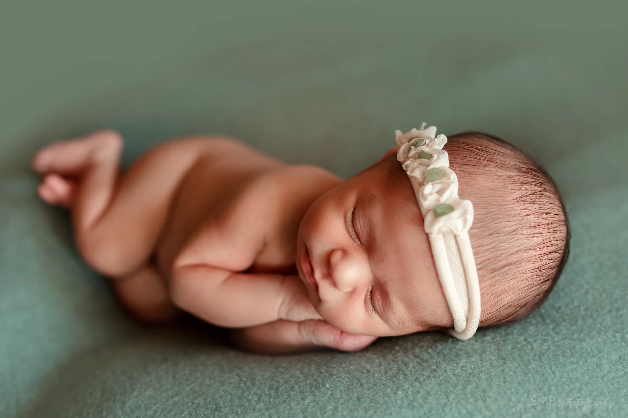 Newborn baby facing camera asleep
