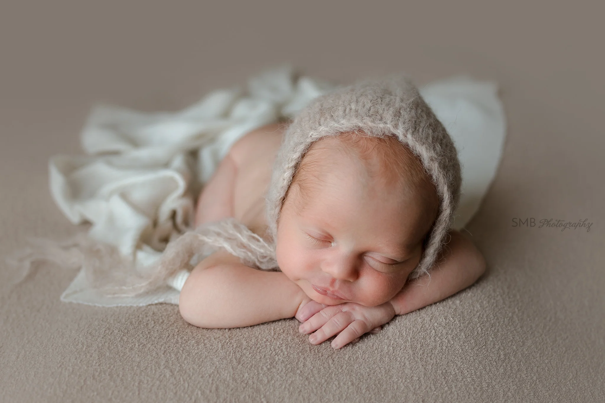 Newborn boy facing camera sleeping