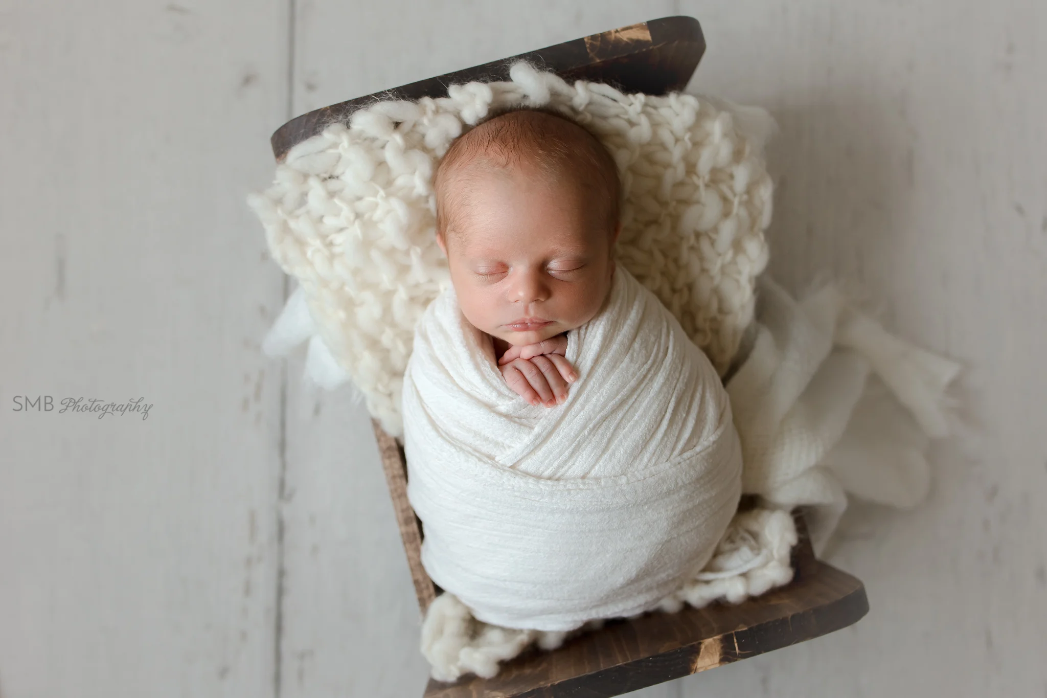 Baby boy wrapped in newborn cradle